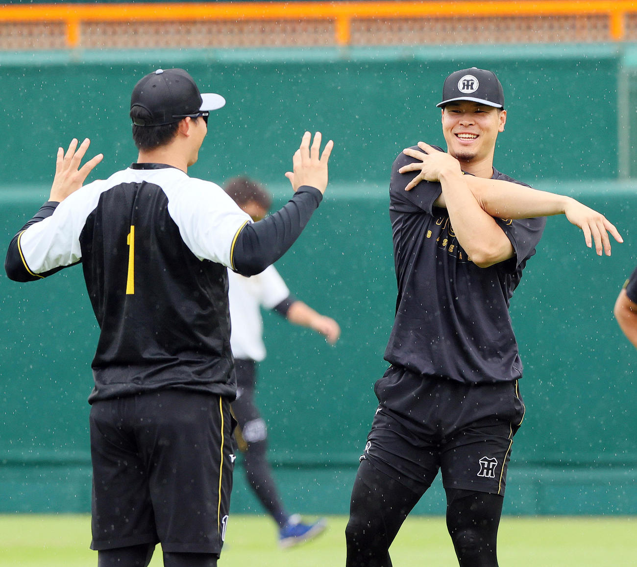 雨が降る中アップする阪神佐藤輝（右）と森下（撮影・上山淳一）