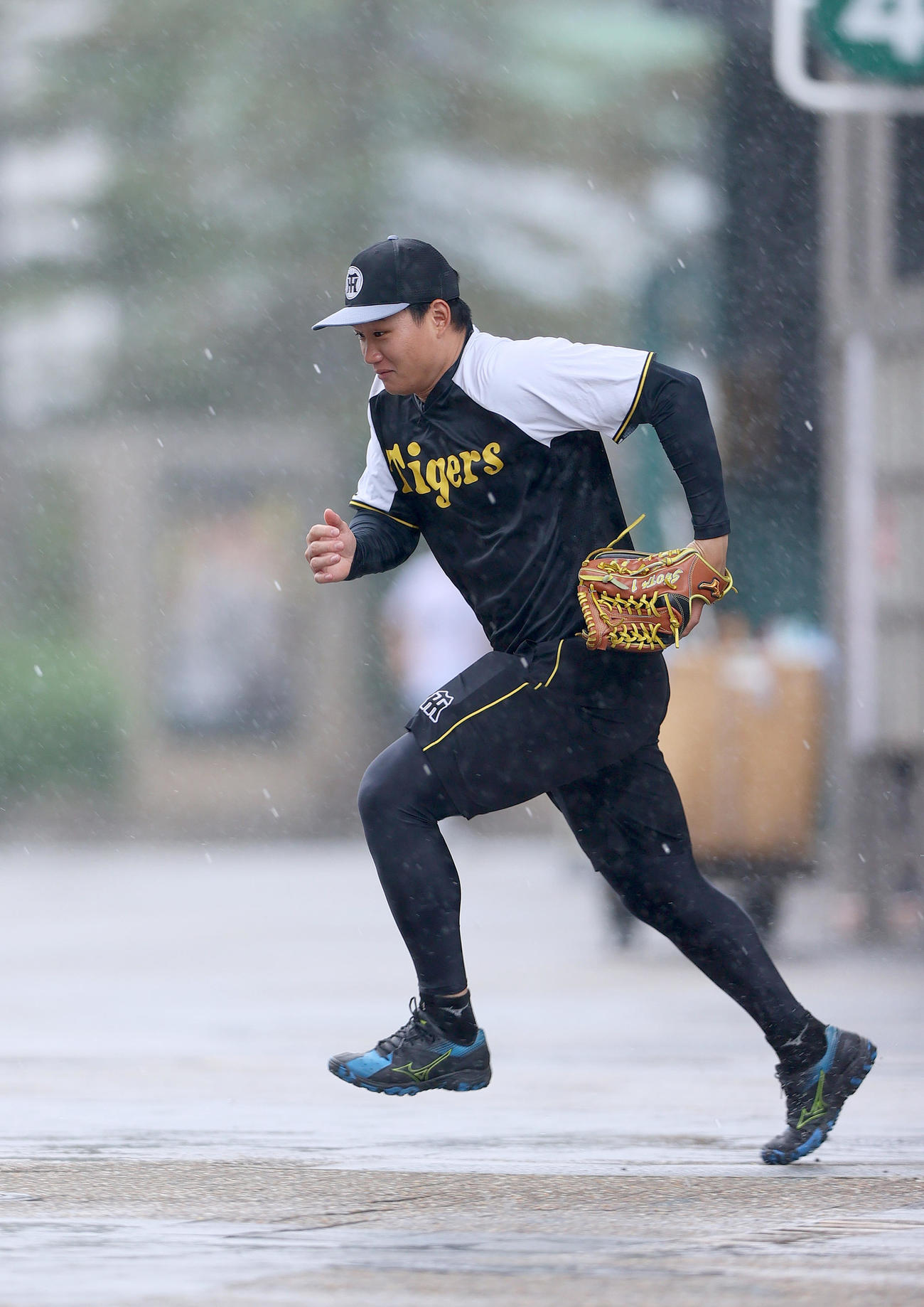 雨が降り室内練習場にダッシュで移動する阪神森下（撮影・上山淳一）