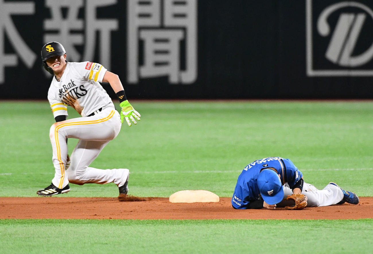 ソフトバンク対日本ハム　1回裏ソフトバンク1死一塁、二盗で交錯し、互いに負傷する周東（左）と遊撃手の山県（撮影・岩下翔太）