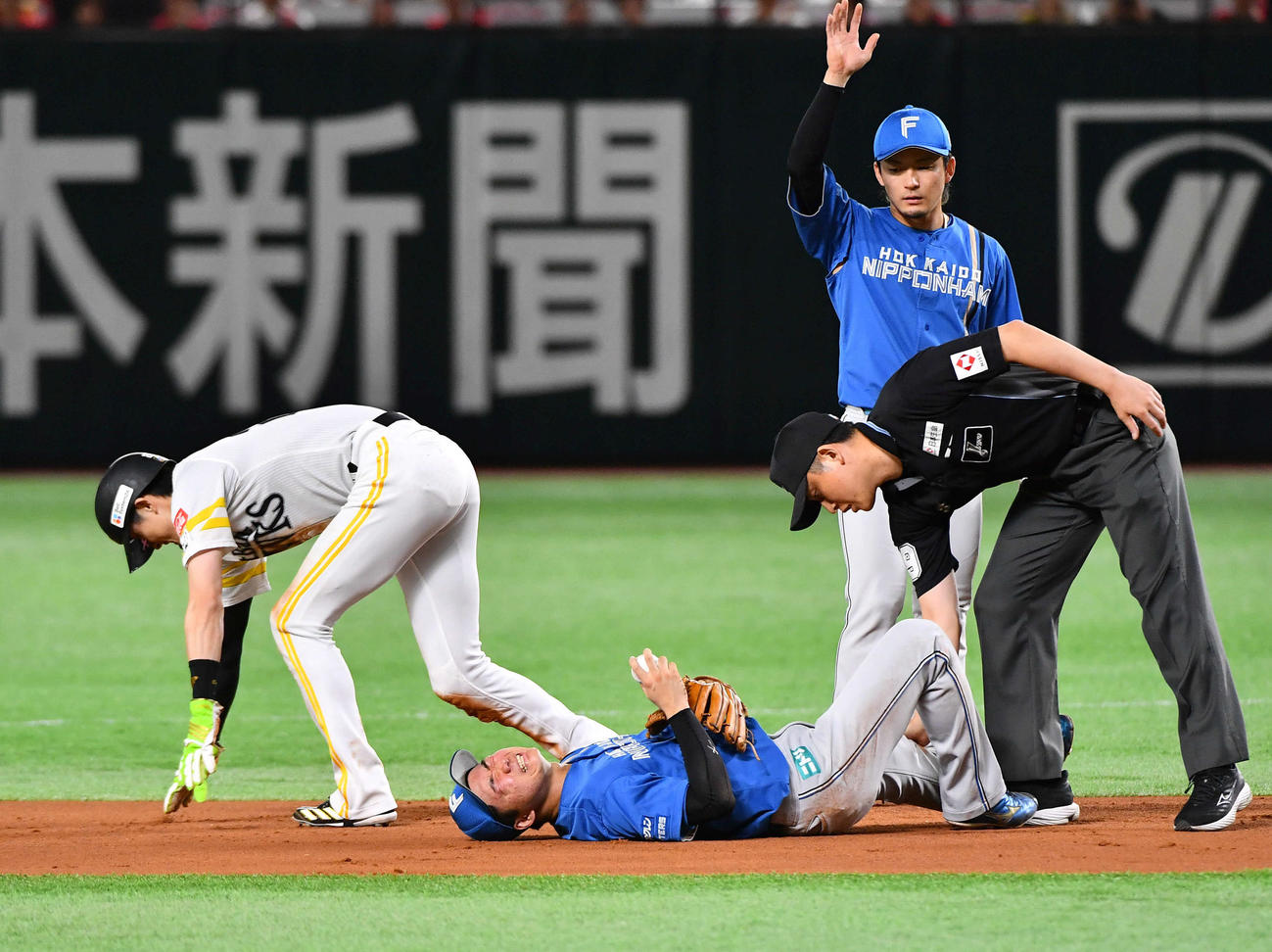 ソフトバンク対日本ハム　1回裏ソフトバンク1死一塁、周東（左）の二盗で交錯し、グラウンドに倒れる遊撃手の山県（撮影・岩下翔太）