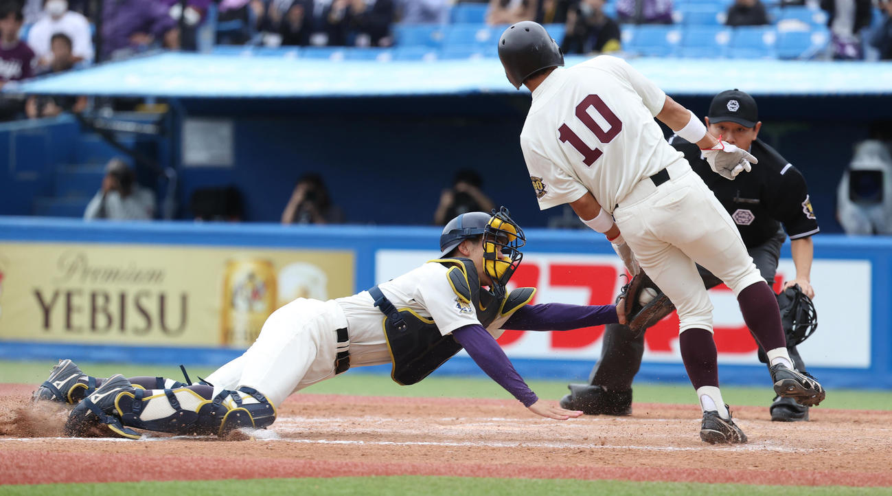 早大対明大　4回表早大1死二、三塁、田村の二邪飛を明大・岡田二塁手が好捕し本塁で三塁走者小沢をアウトにする。明大・小島捕手（撮影・柴田隆二）
