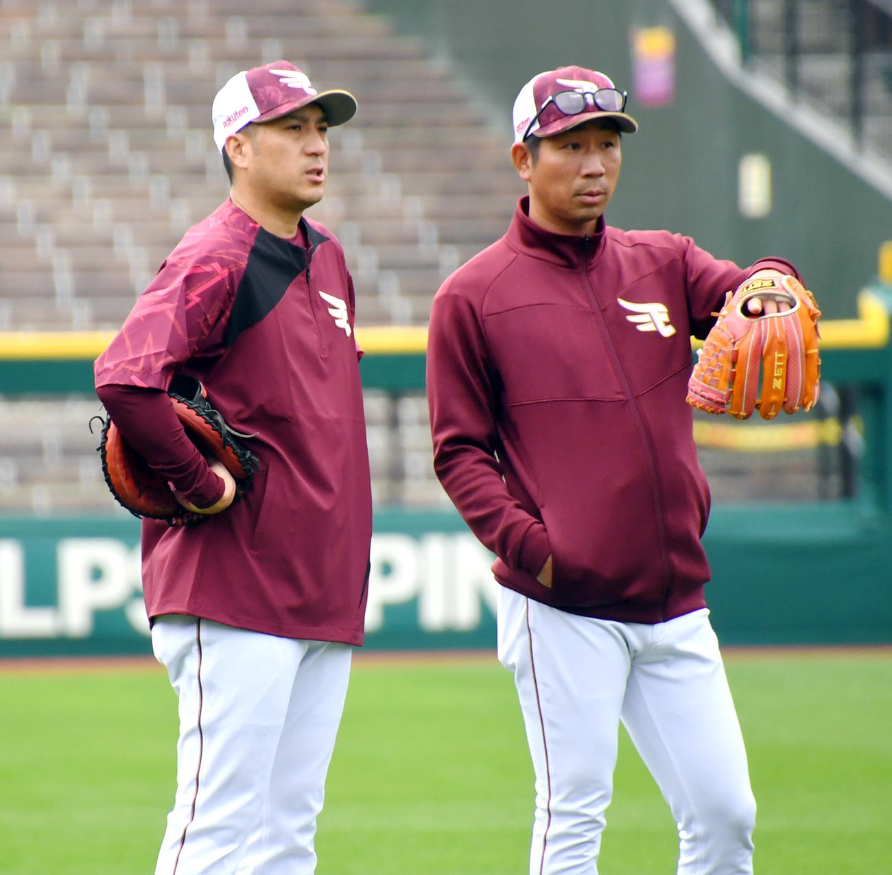 楽天の塩川内野守備走塁コーチ（右）と話し込む新任の井野バッテリーコーチ