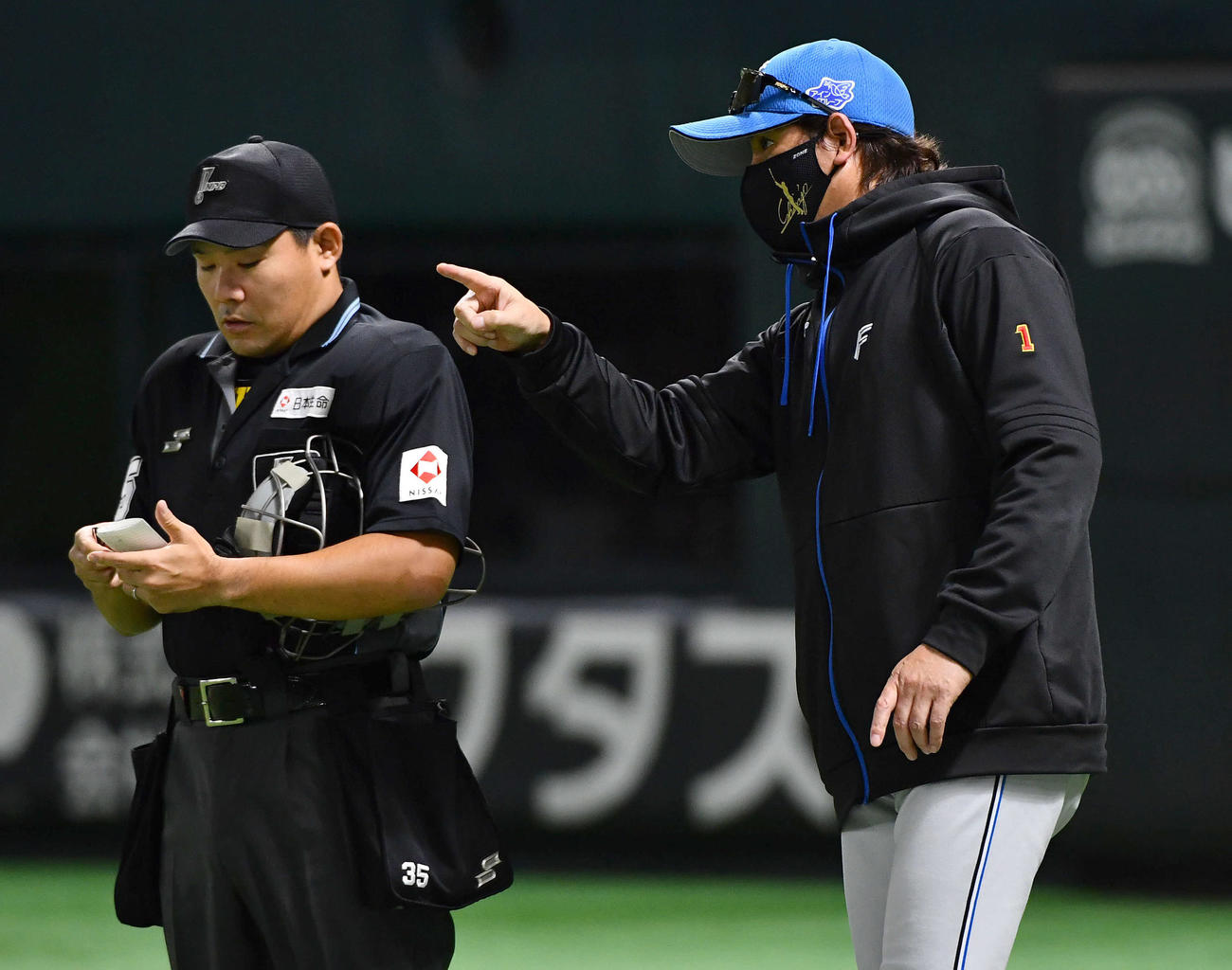 ソフトバンク対日本ハム　1回裏ソフトバンク1死一塁、周東の二盗の際に交錯して担架で運ばれた山県の交代を告げる新庄監督（撮影・岩下翔太）