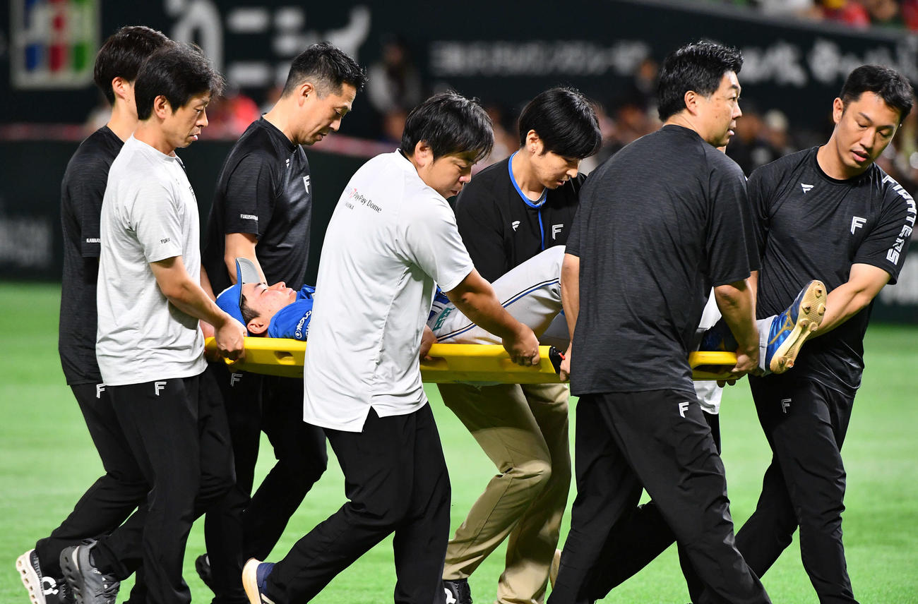 ソフトバンク対日本ハム　1回裏ソフトバンク1死一塁、周東の二盗のベースカバーで衝突し、担架で運ばれる山県（撮影・岩下翔太）