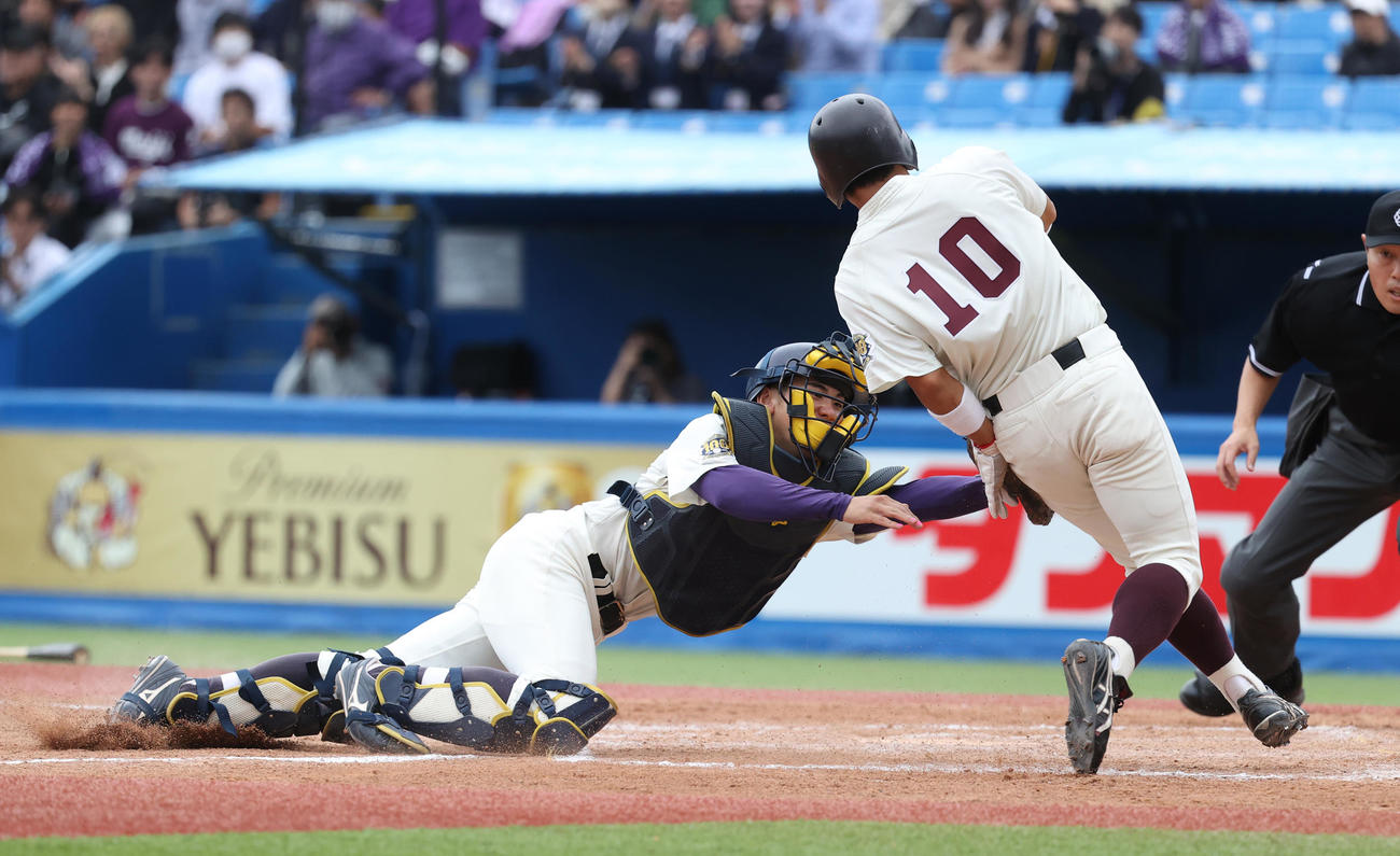早大対明大　4回表早大1死二、三塁、田村の二邪飛を明大・岡田二塁手が好捕し本塁で三塁走者小沢をアウトにする。明大・小島捕手（撮影・柴田隆二）