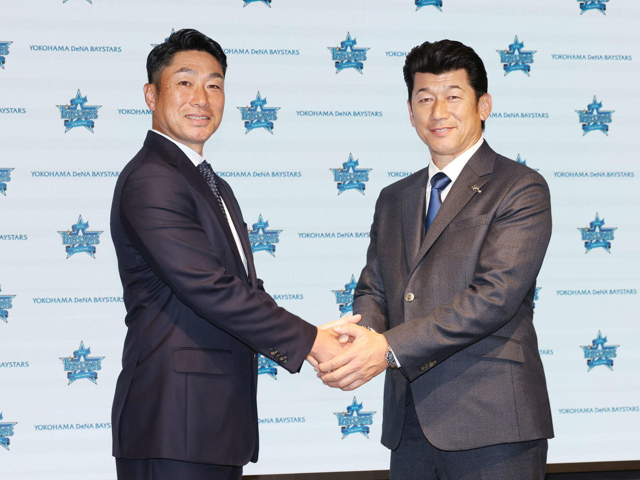 笑顔で握手するDeNA相川新監督（左）と三浦監督（撮影・宮地輝）