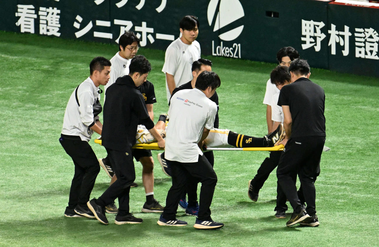 ソフトバンク対日本ハム　3回裏ソフトバンク2死一塁、一塁付近で審判と接触し担架で運ばれる中村（撮影・林敢治）