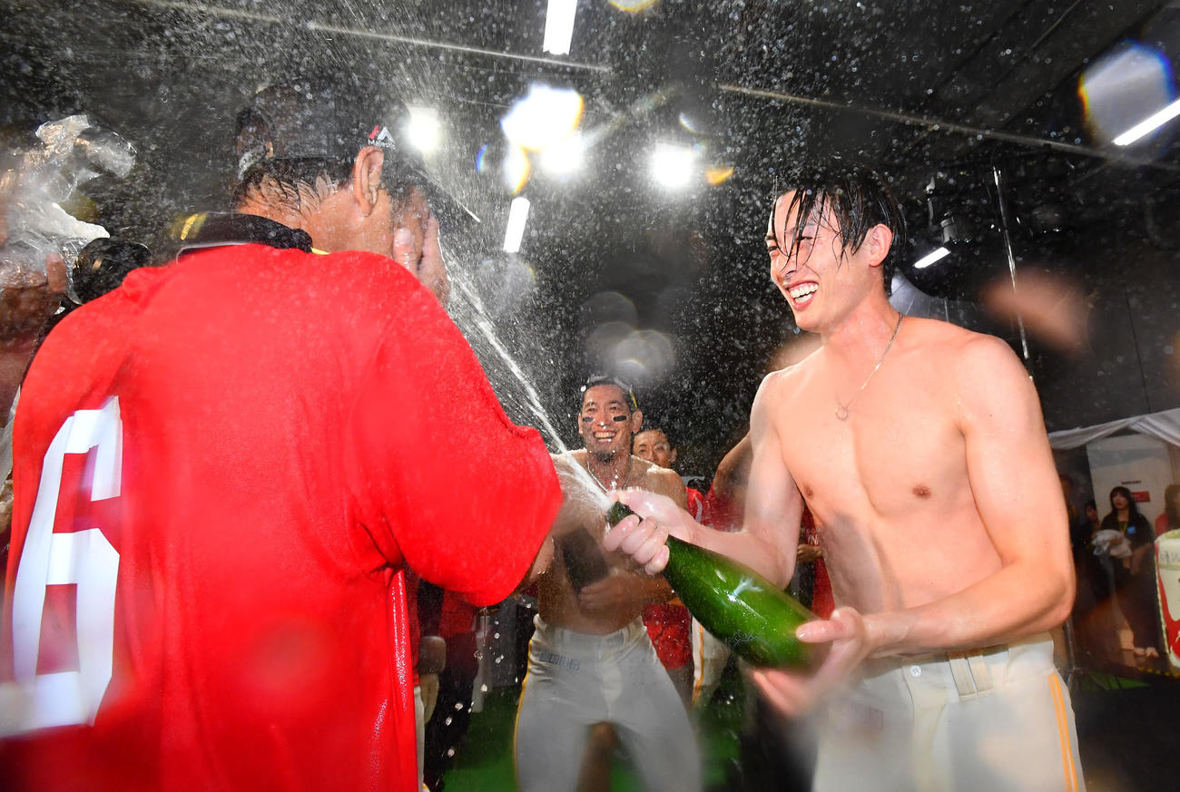 シャンパンファイトを楽しむ周東、左は今宮（撮影・岩下翔太）