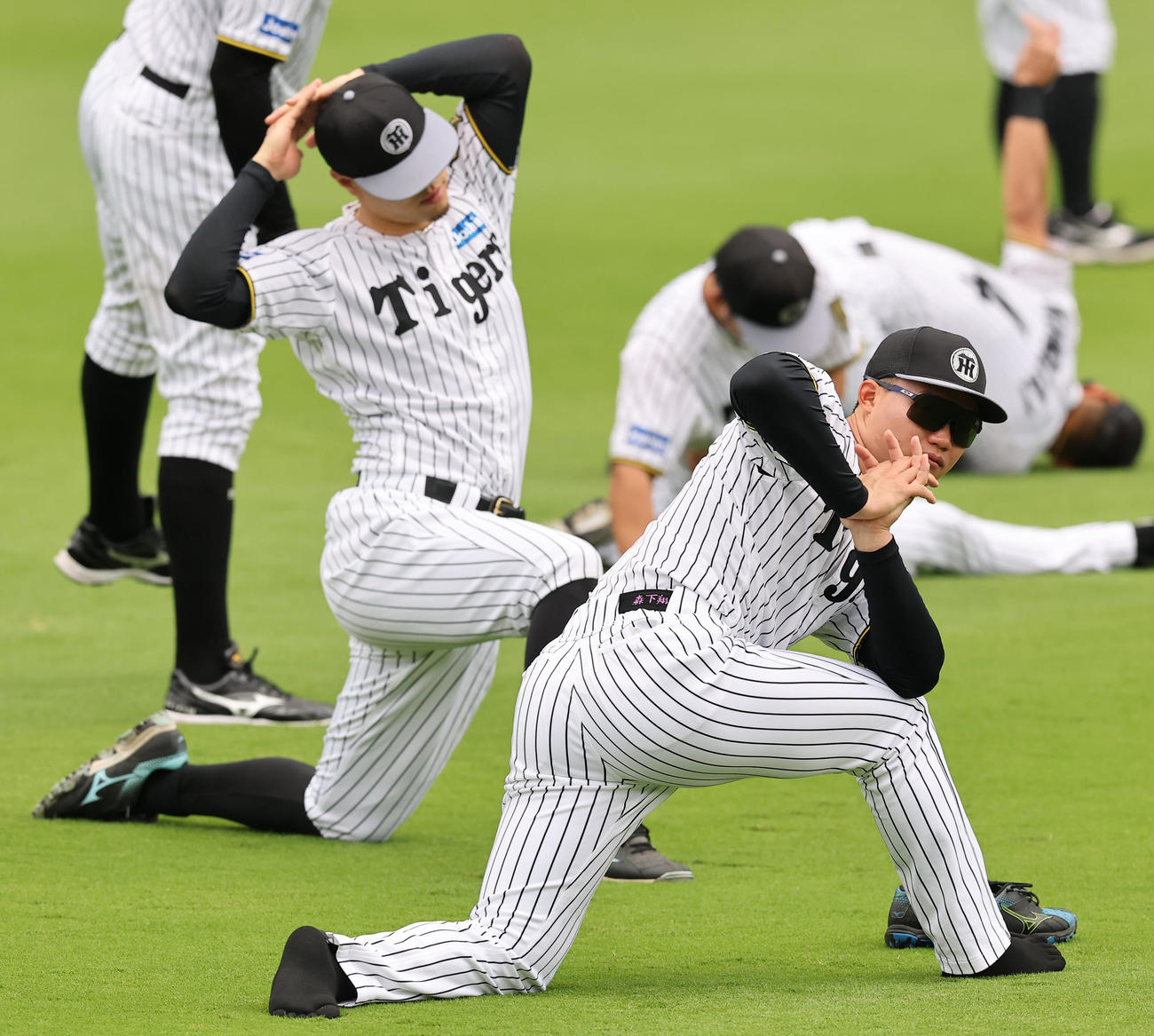 外野でスパイクを脱いでストレッチをする森下（撮影・上田博志）