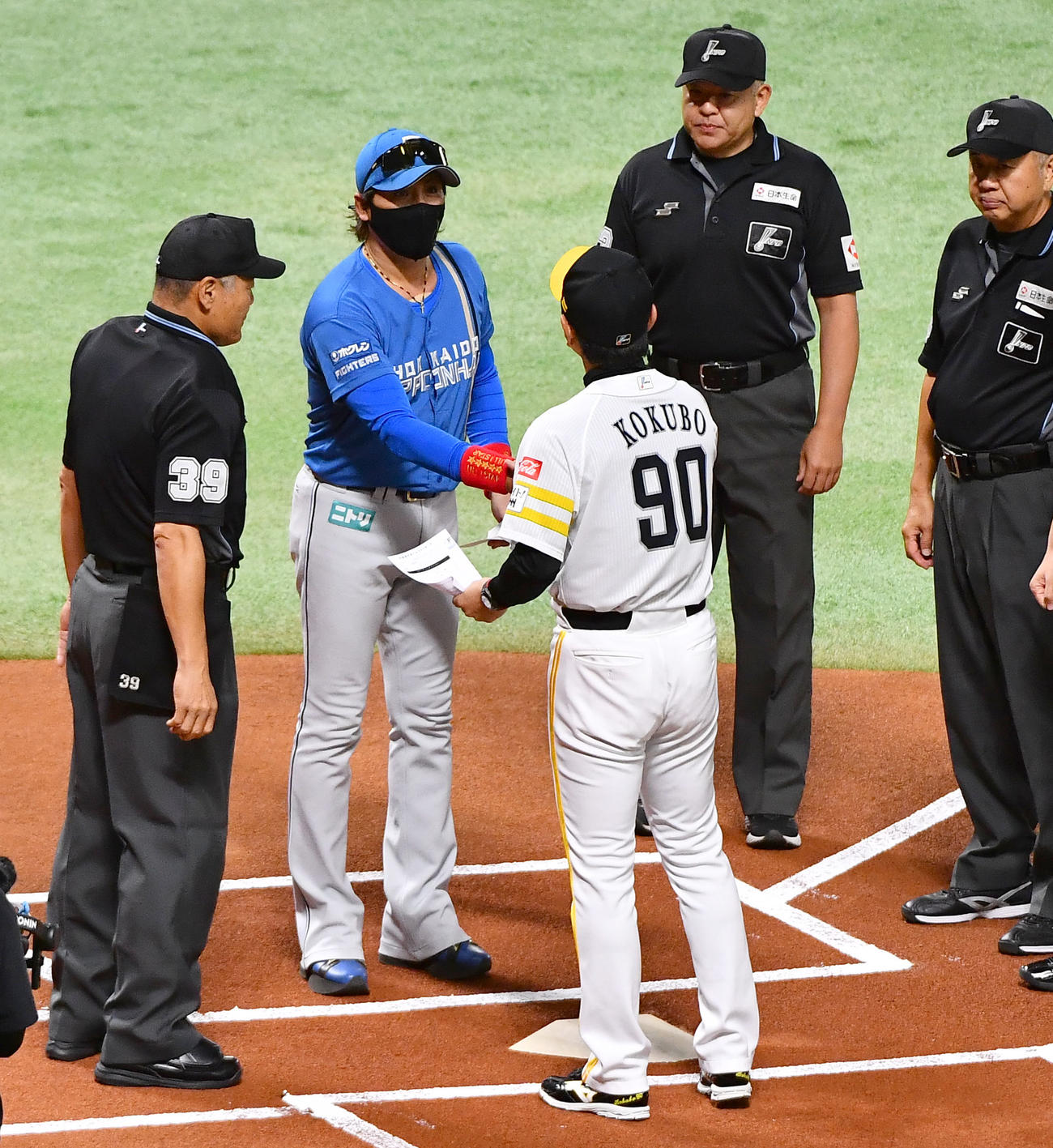 ソフトバンク対日本ハム　試合前、ソフトバンク小久保監督（右）とメンバー表を交換し、握手を交わす日本ハム新庄監督（撮影・岩下翔太）