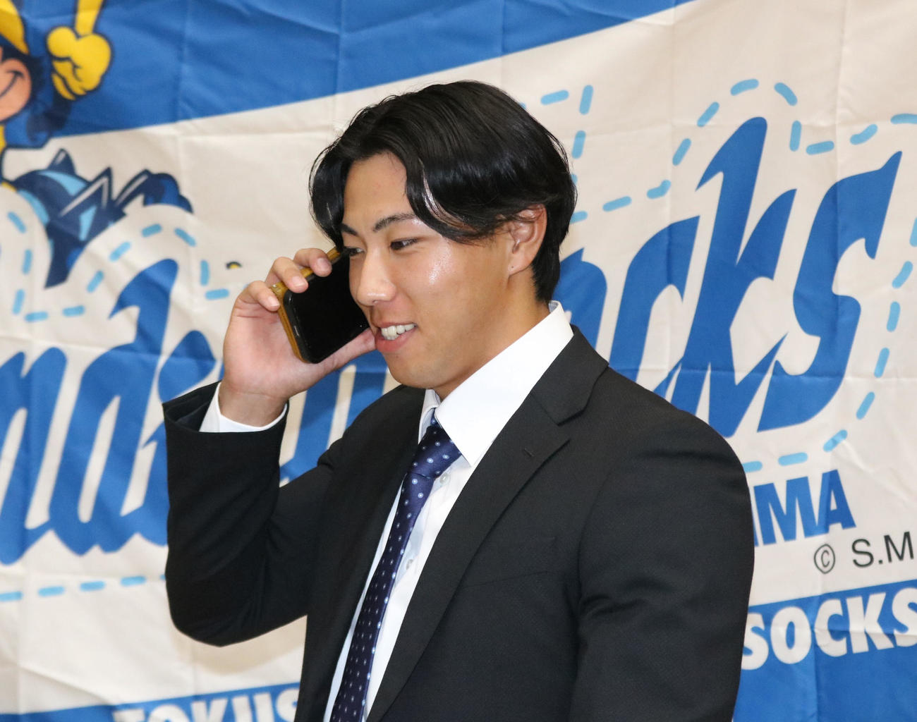2024年10月24日、阪神から育成1位指名を受けた四国IL徳島の工藤泰成投手が担当の山本スカウトから電話を受け、笑顔で話しをする