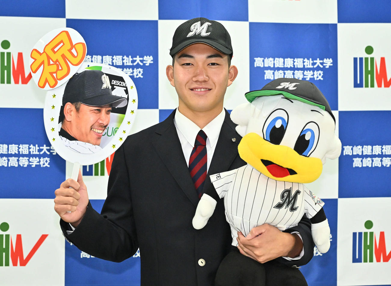 ロッテからドラフト1位で指名された健大高崎・石垣はサブロー新監督の写真とマーくんを手に記念撮影する（撮影・滝沢徹郎）