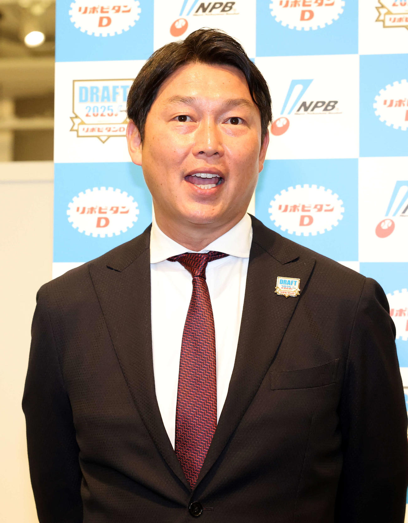 ドラフト1巡目を終え、笑顔で質問に答える広島新井監督（撮影・浅見桂子）