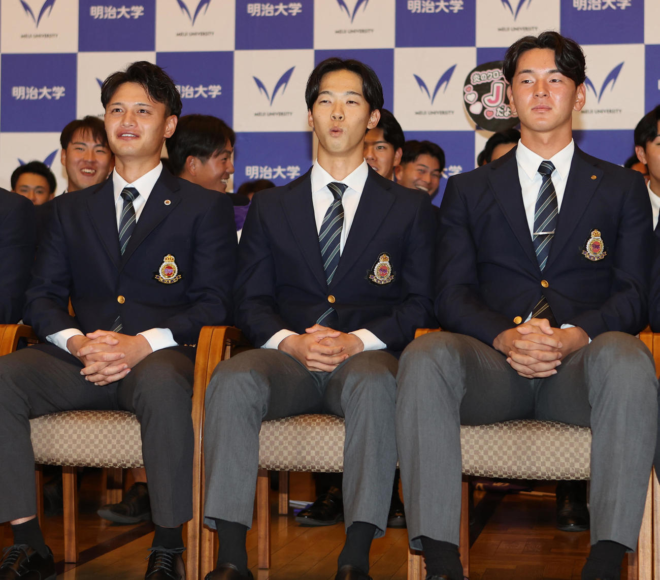 日本ハムにドラフト1位で指名され驚いたような表情を見せる明大・大川（中央）。左は毛利、右は高須（撮影・水谷安孝）