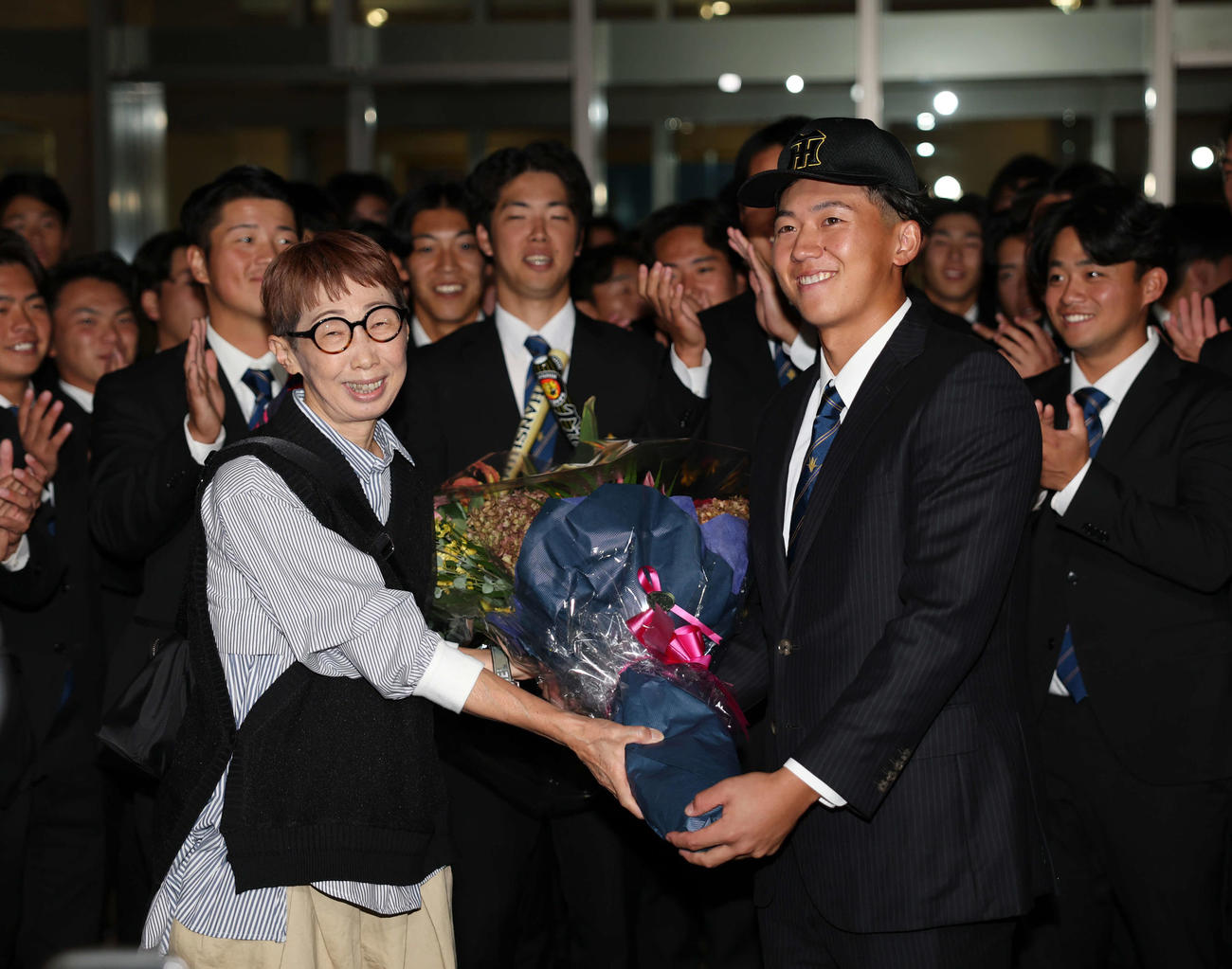 阪神からドラフト1位で指名された創価大・立石（右）は母・郁代さんに花束を渡し笑顔を見せる（撮影・増田悦実）