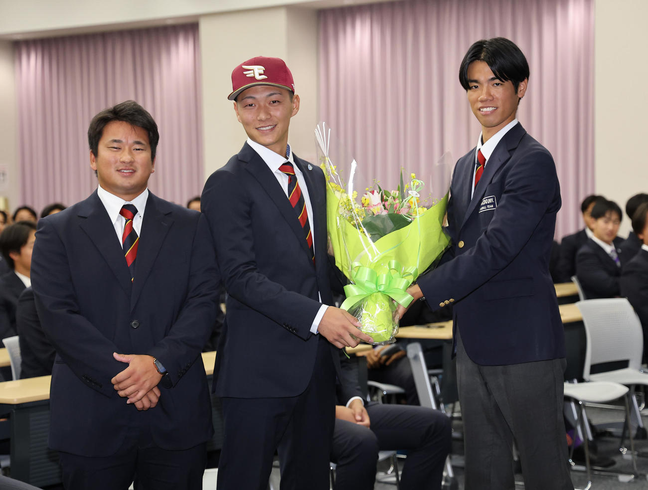 楽天からドラフト1位指名を受けた花園大・藤原（中央）はチームメートから花束を受け取る（撮影・上田博志）
