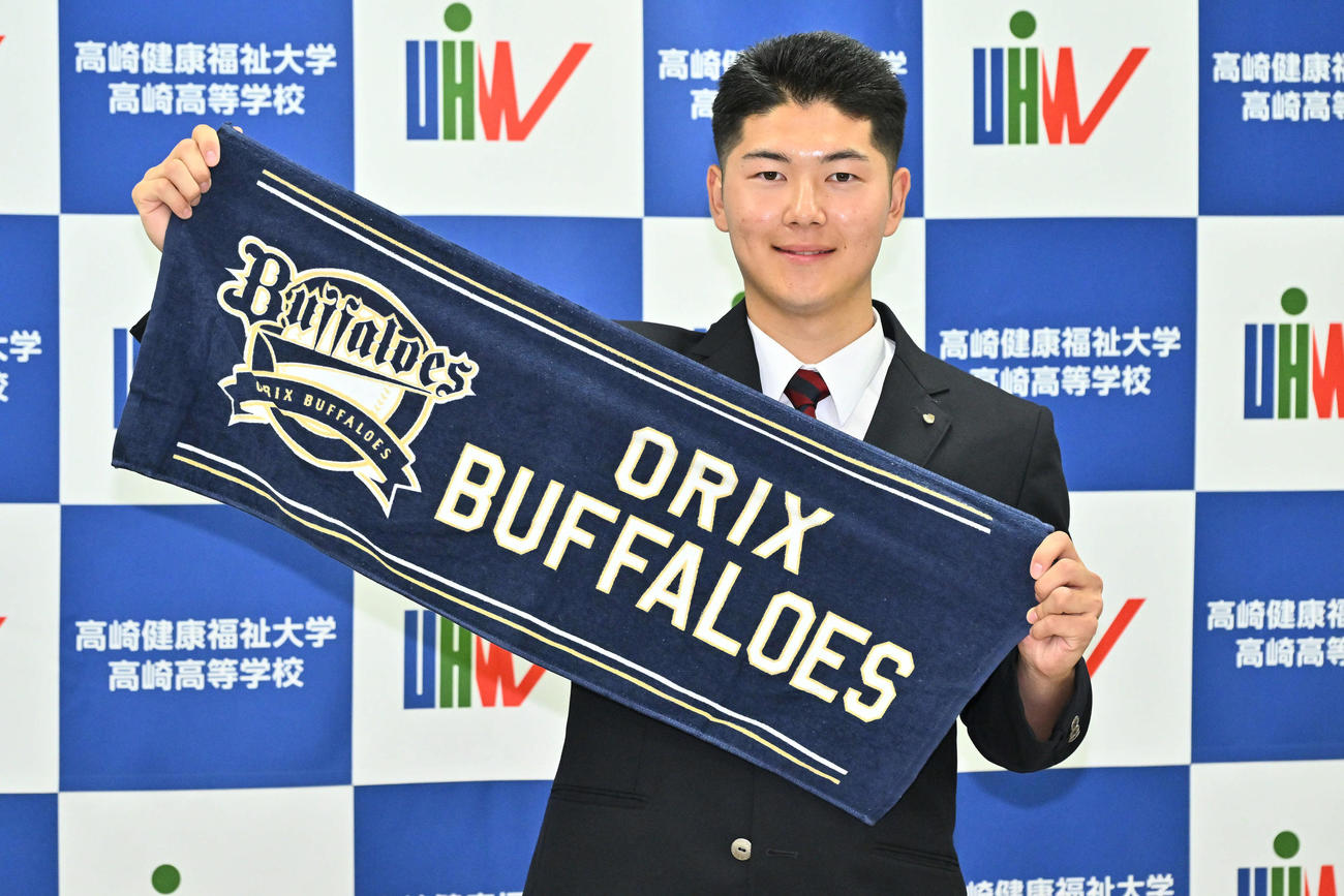 オリックスからドラフト3位で指名された佐藤はオリックスのタオルを手に記念撮影する（撮影・滝沢徹郎）