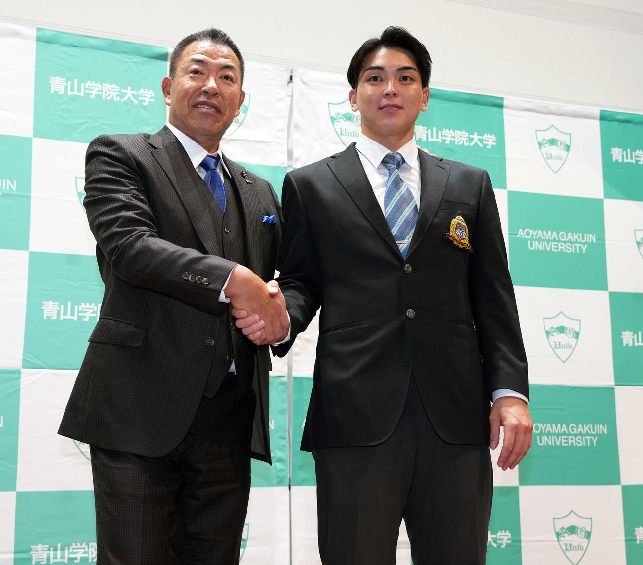 駆けつけた中日井上監督（左）と握手する中日ドラフト1位の青学大・中西（撮影・小島史椰）
