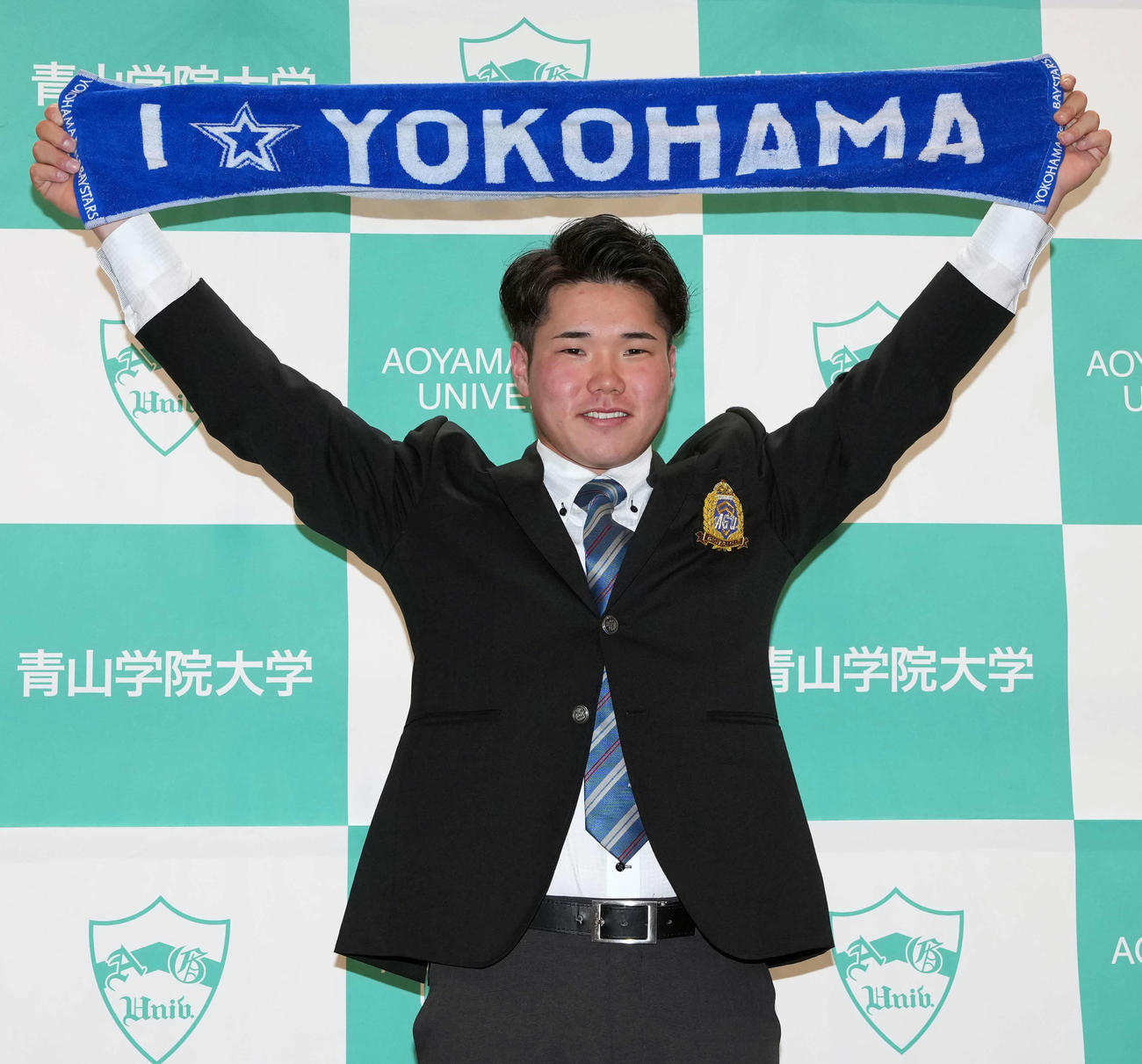 DeNAから外れ1位指名を受けタオルを掲げる学大・小田康一郎（撮影・小島史椰）