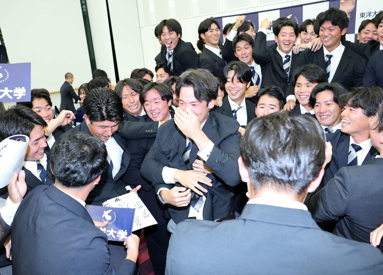 仲間に祝福され涙ぐむ中日6位指名の東洋大・花田（中央）（撮影・鈴木正人）
