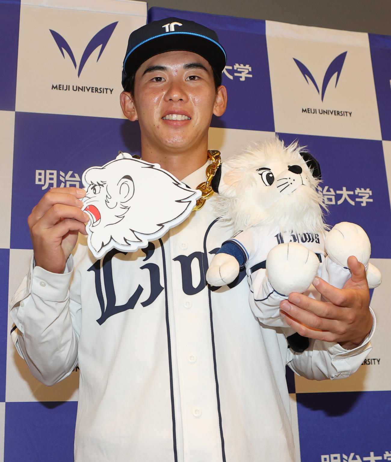 西武にドラフト1位で指名されレオ人形を手に笑顔を見せる明大・小島（撮影・水谷安孝）