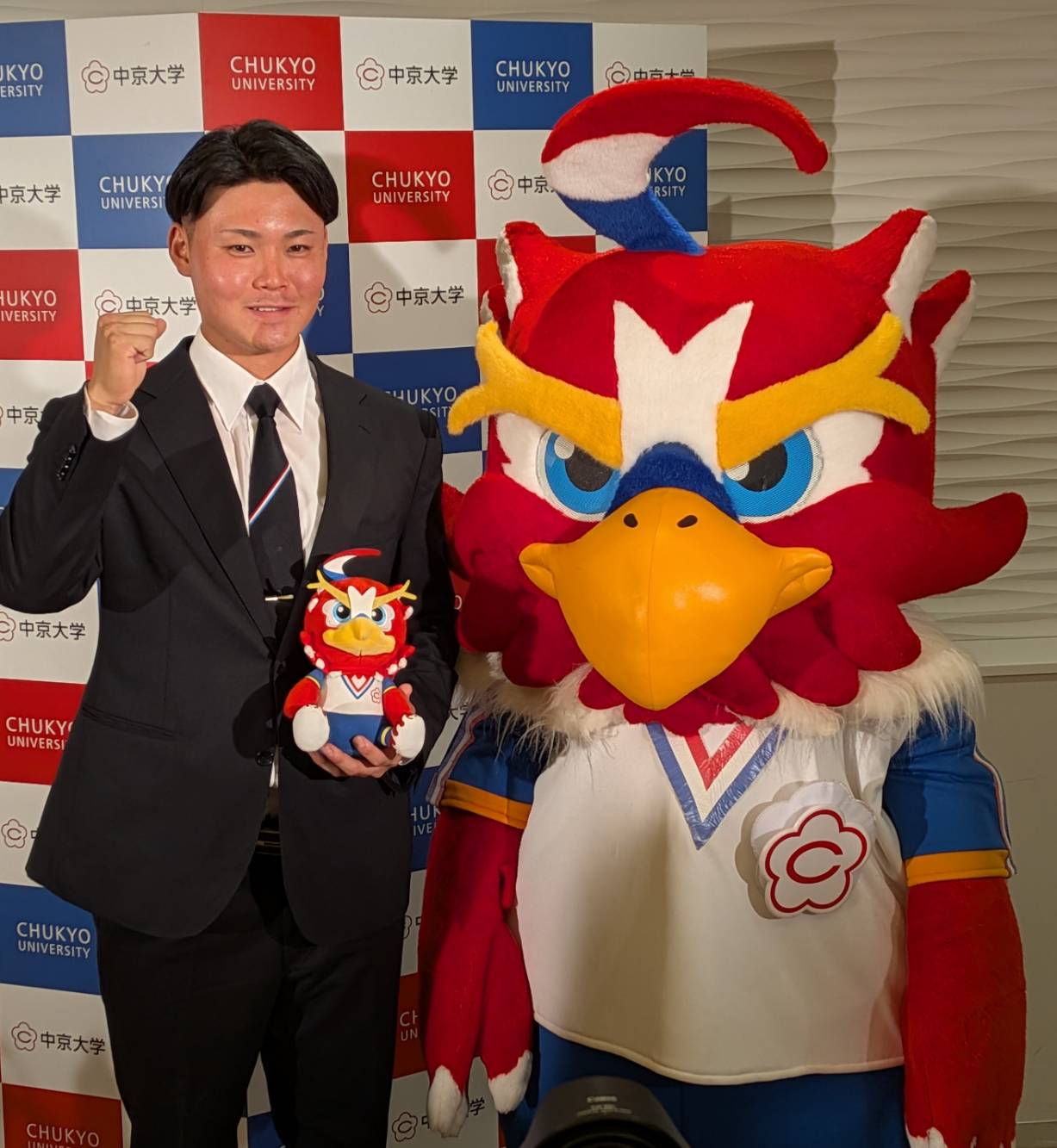 西武3位指名のの中京大・秋山俊は大学のマスコット「チューグル」と並んでガッツポーズ（撮影・柏原誠）＝2025年10月23日