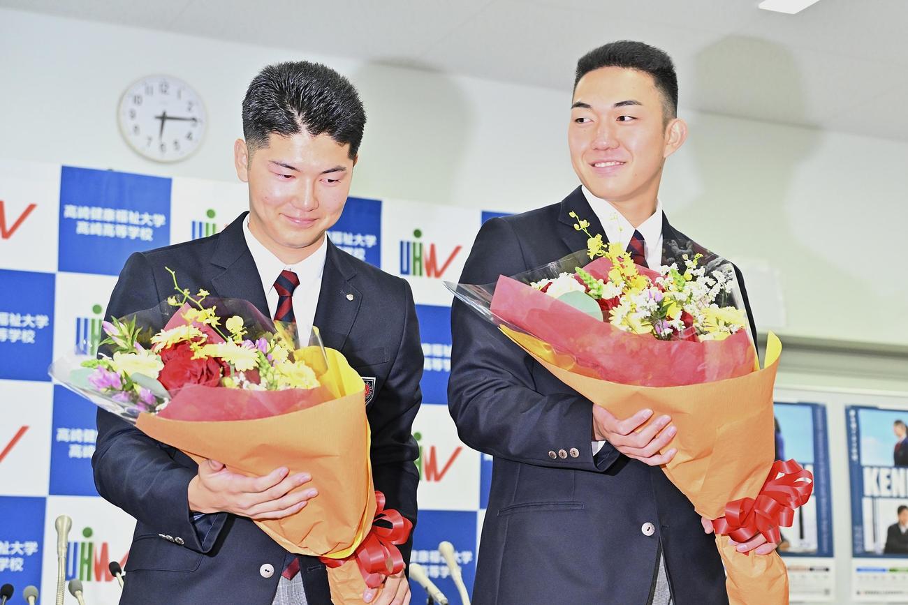 ロッテからドラフト1位で指名された健大高崎・石垣（右）とオリックスからドラフト3位で指名された佐藤は花束を受け取る（撮影・滝沢徹郎）
