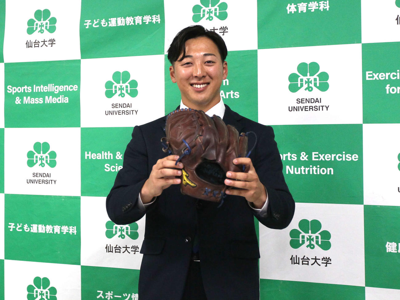 グローブを手に笑顔の仙台大・渡辺一生（撮影・高橋香奈）