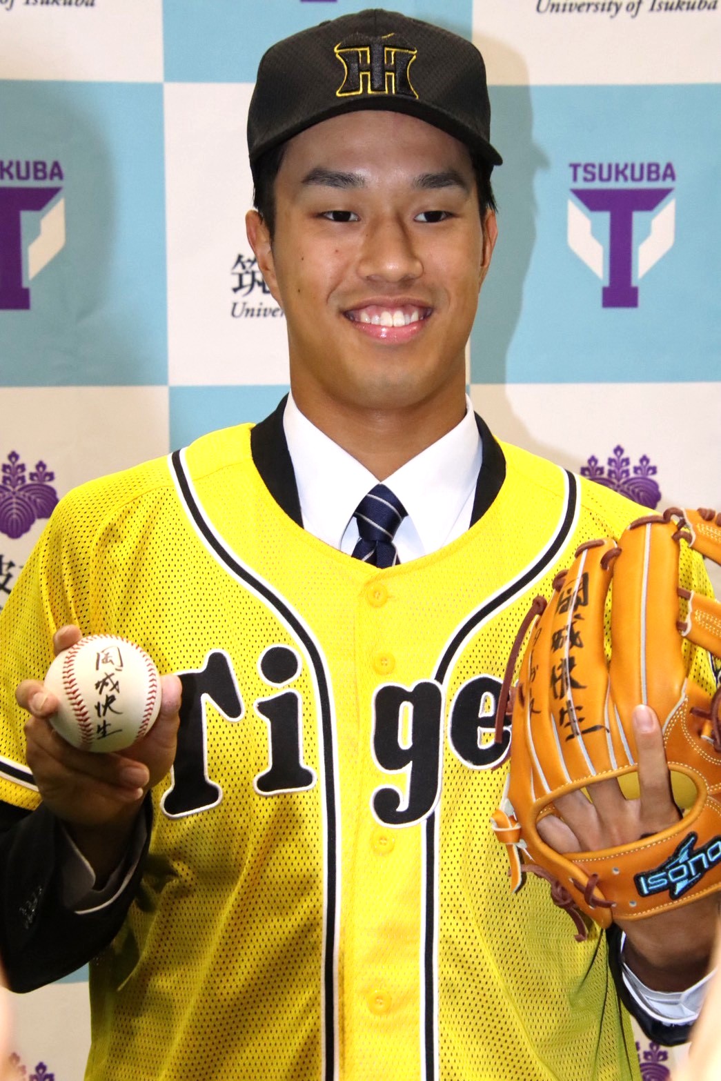 阪神に3位指名され、グラブとボールでポーズをとる筑波大・岡城（筑波大提供）