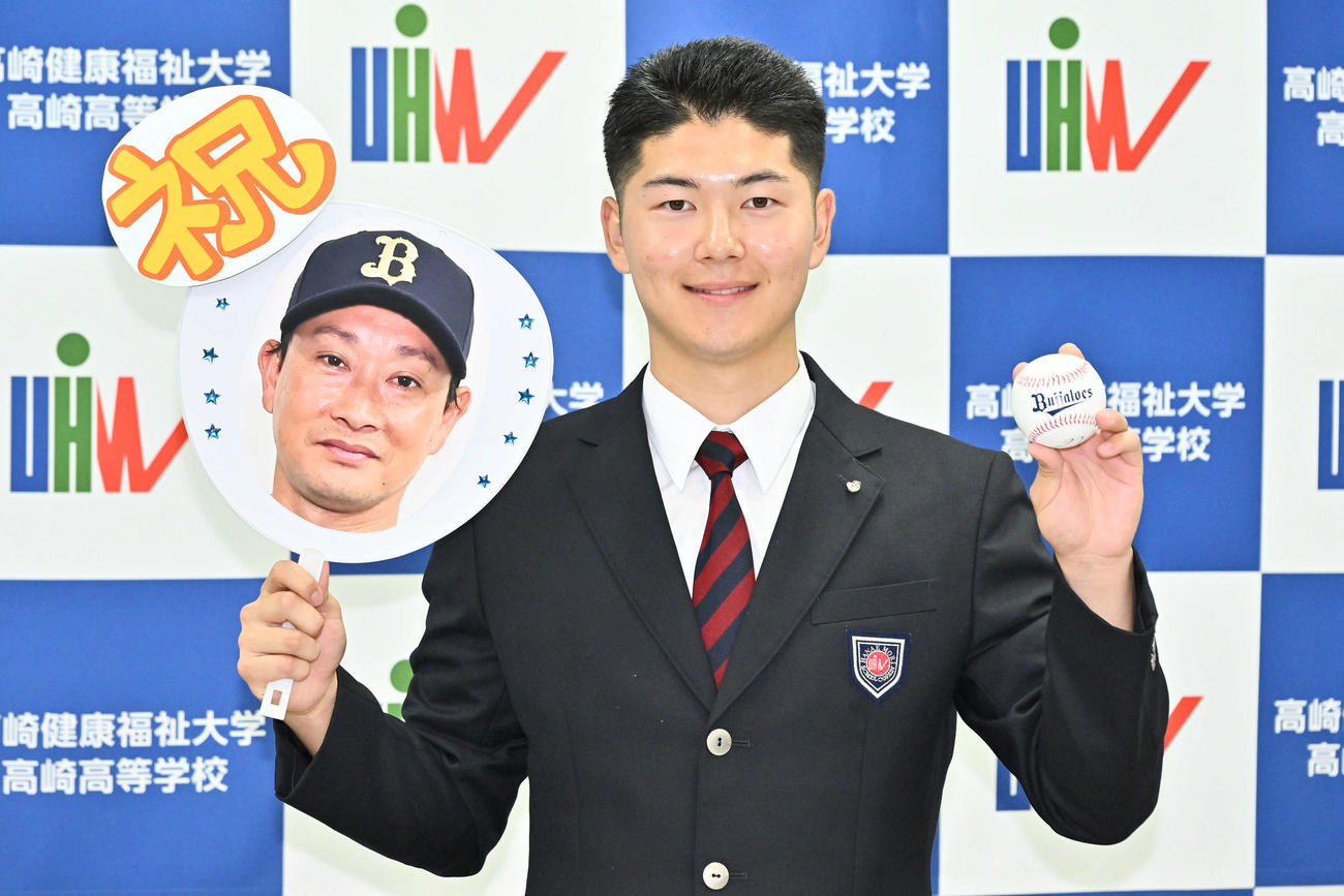 オリックスからドラフト3位で指名された佐藤は岸田護監督の写真を手に記念撮影する（撮影・滝沢徹郎）
