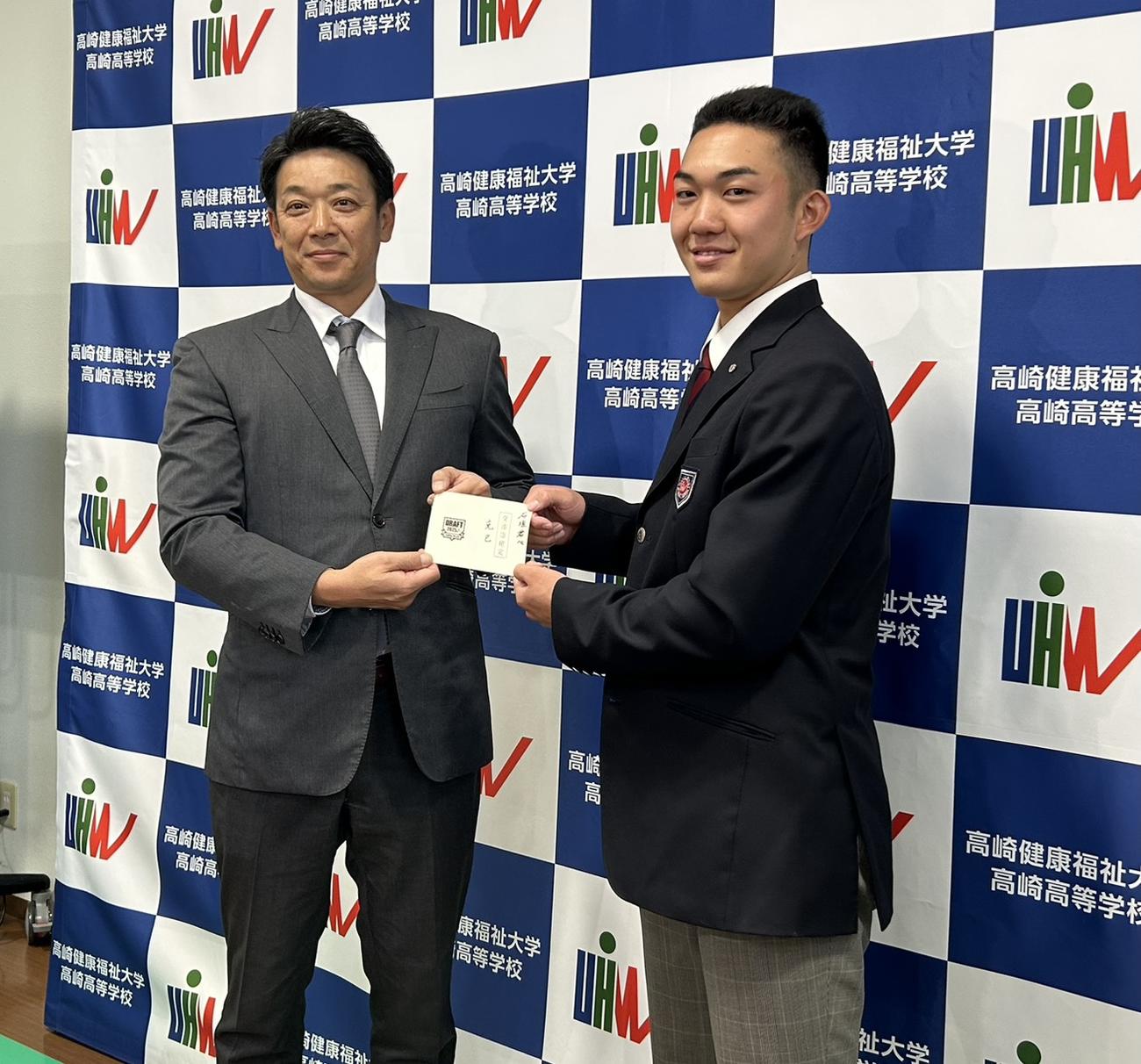 サブロー監督（左）から指名あいさつを受けた健大高崎・石垣（撮影・星夏穂）