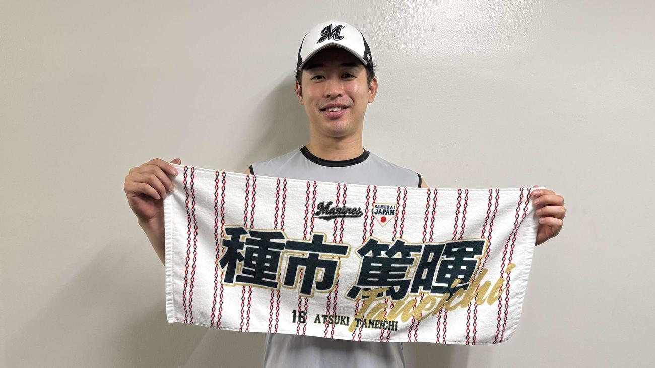 「野球日本代表侍ジャパン」×マリーンズコラボグッズフェイスタオルを持つ種市（球団提供）