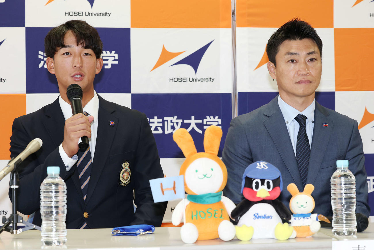 指名あいさつを受け意気込みを語るヤクルトドラフト1位の法大・松下。右は青木GM特別補佐（撮影・宮地輝）