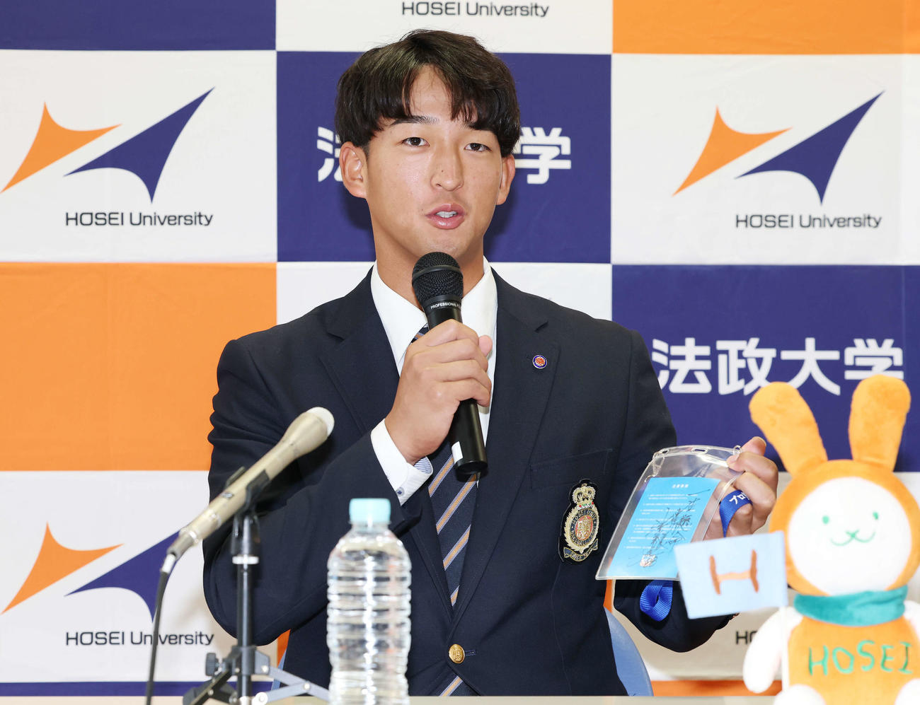 指名あいさつを受け、ヤクルト池山監督の直筆メッセージ入りパスを手に意気込みを語るドラフト1位の法大・松下（撮影・宮地輝）