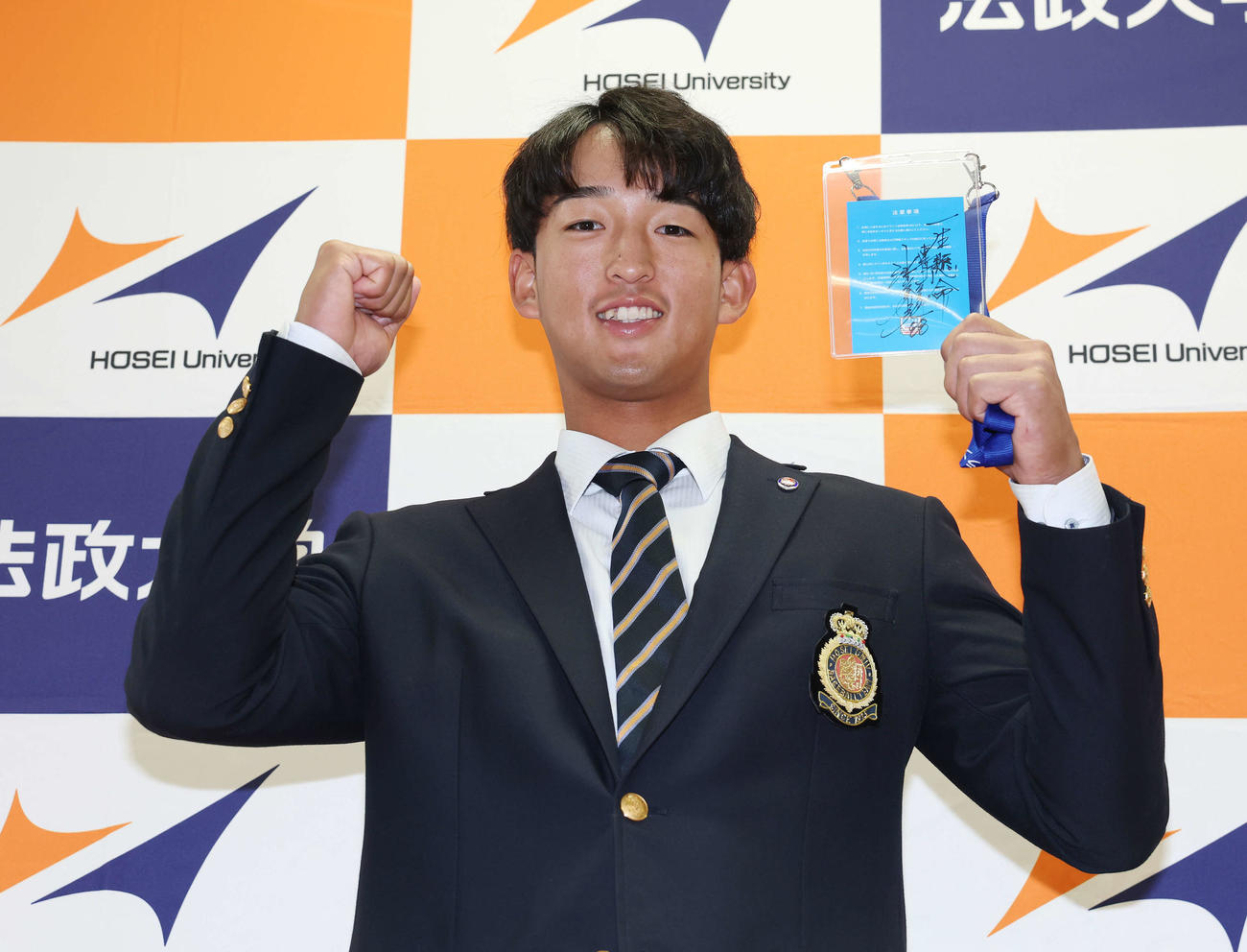 指名あいさつを受け、ヤクルト池山監督の直筆メッセージ入りパスを手に笑顔を見せるドラフト1位の法大・松下（撮影・宮地輝）