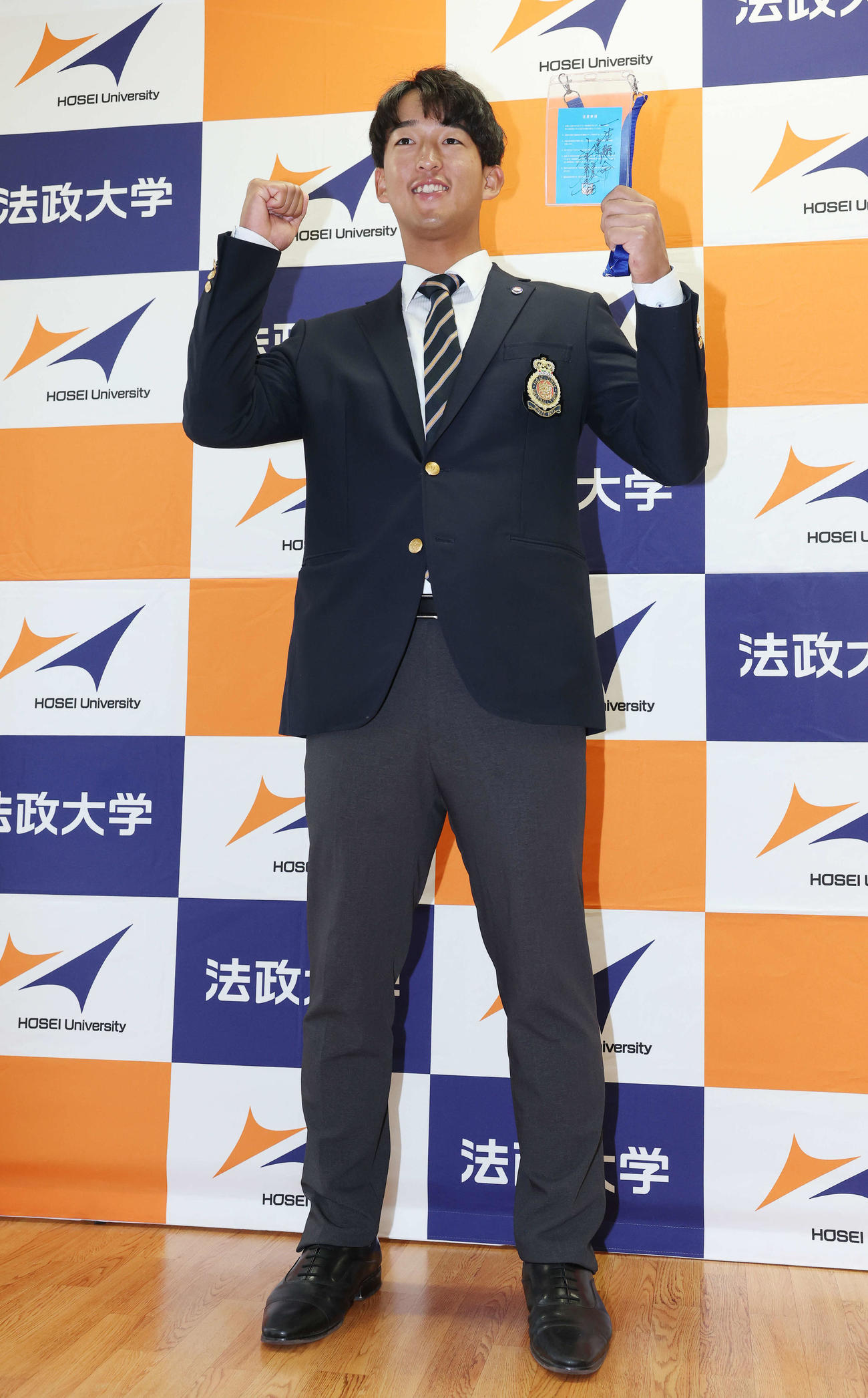 指名あいさつを受け、ヤクルト池山監督の直筆メッセージ入りパスを手に笑顔を見せるドラフト1位の法大・松下（撮影・宮地輝）