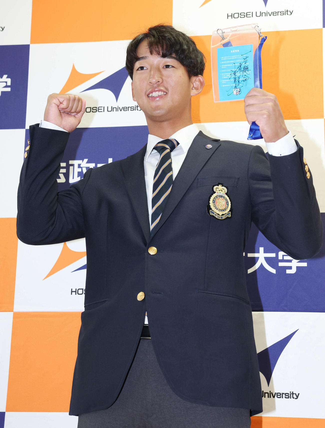 指名あいさつを受け、ヤクルト池山監督の直筆メッセージ入りパスを手に笑顔を見せるドラフト1位の法大・松下（撮影・宮地輝）