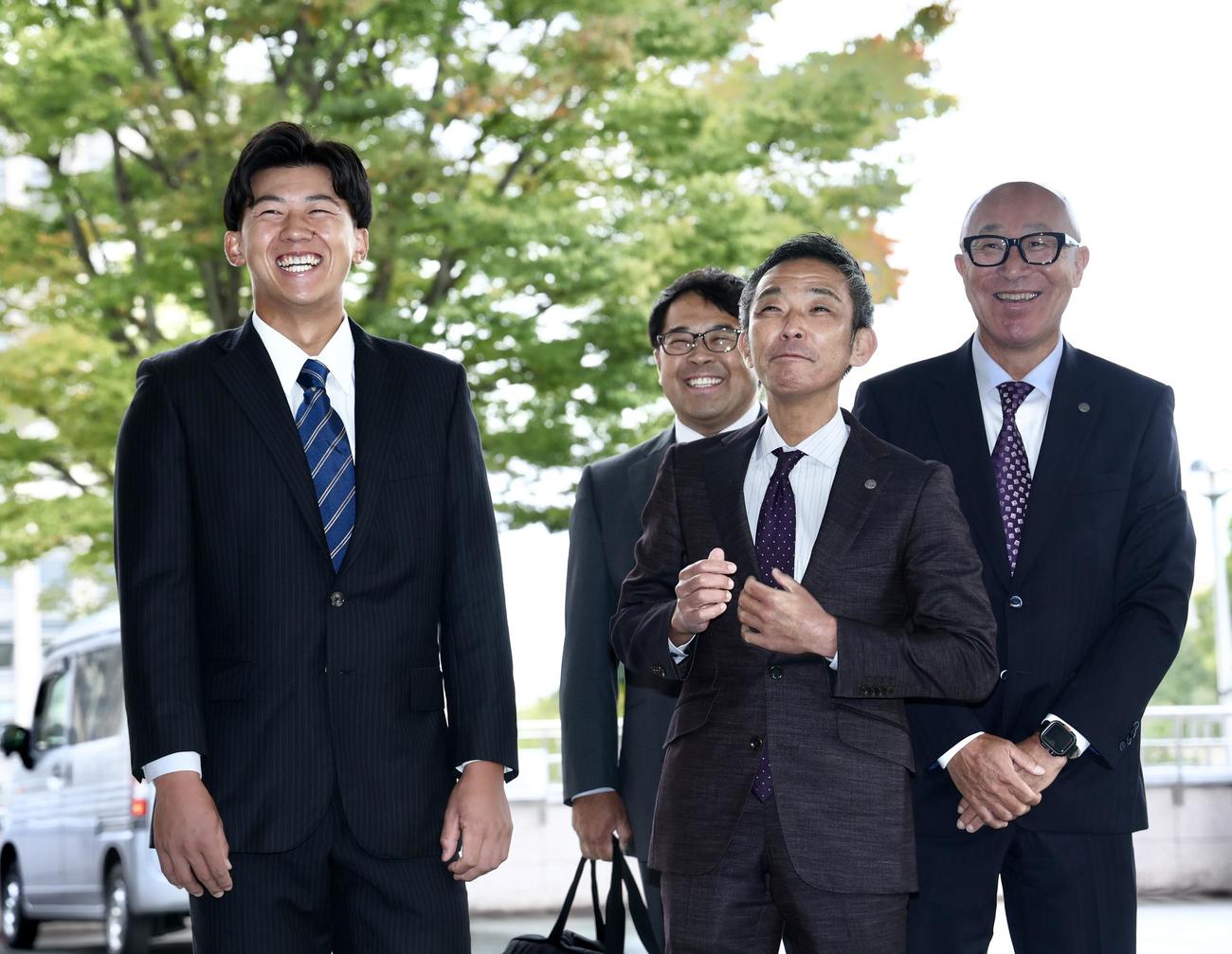 阪神球団職員を笑顔で迎える創価大・立石（左）。右から阪神畑山統括スカウト、竹内副本部長、東編成ディレクター（撮影・河田真司）