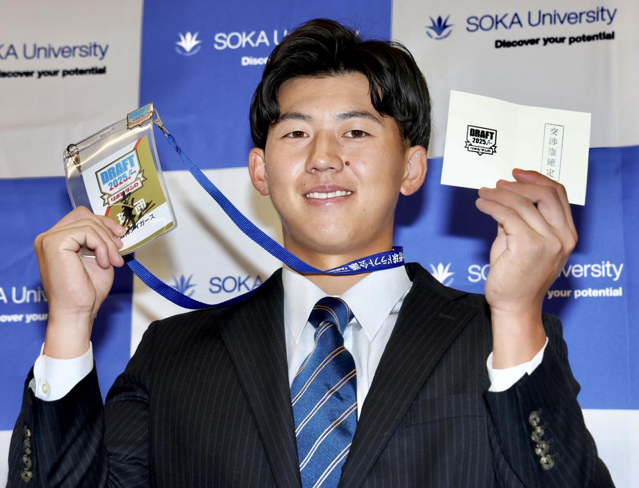 阪神藤川監督のサインが入ったドラフト会議2025のIDと交渉権確定の印が押されたくじを手に笑顔で写真に納まる創価大・立石（撮影・河田真司）