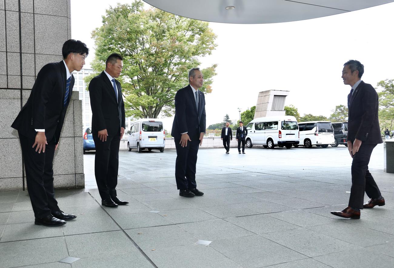 阪神竹内副本部長（右）を出迎える、左から創価大・立石、高口コーチ、佐藤監督（撮影・河田真司）