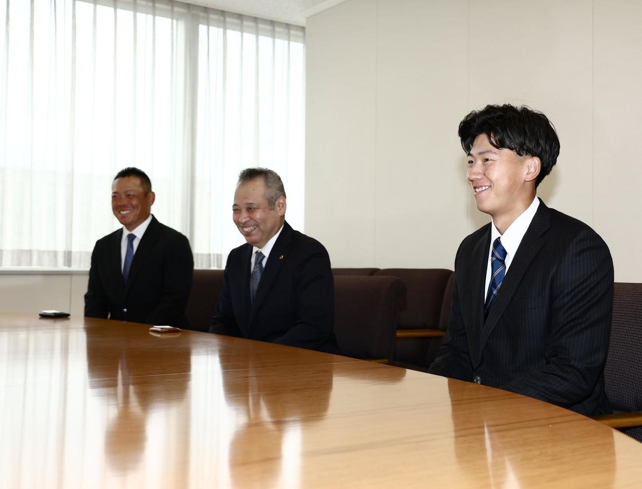 阪神球団職員のあいさつを笑顔で聞く、右から創価大・立石、佐藤監督、高口コーチ（撮影・河田真司）