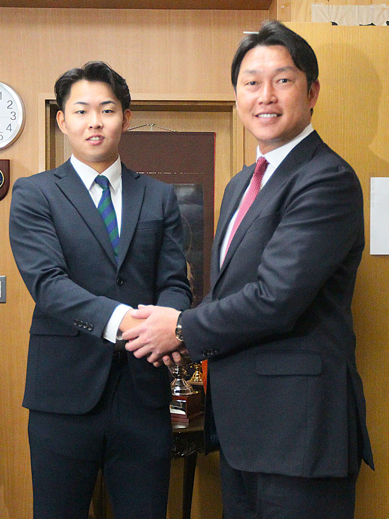握手を交わす広島・新井監督（左）と仙台大・平川（撮影・高橋香奈）