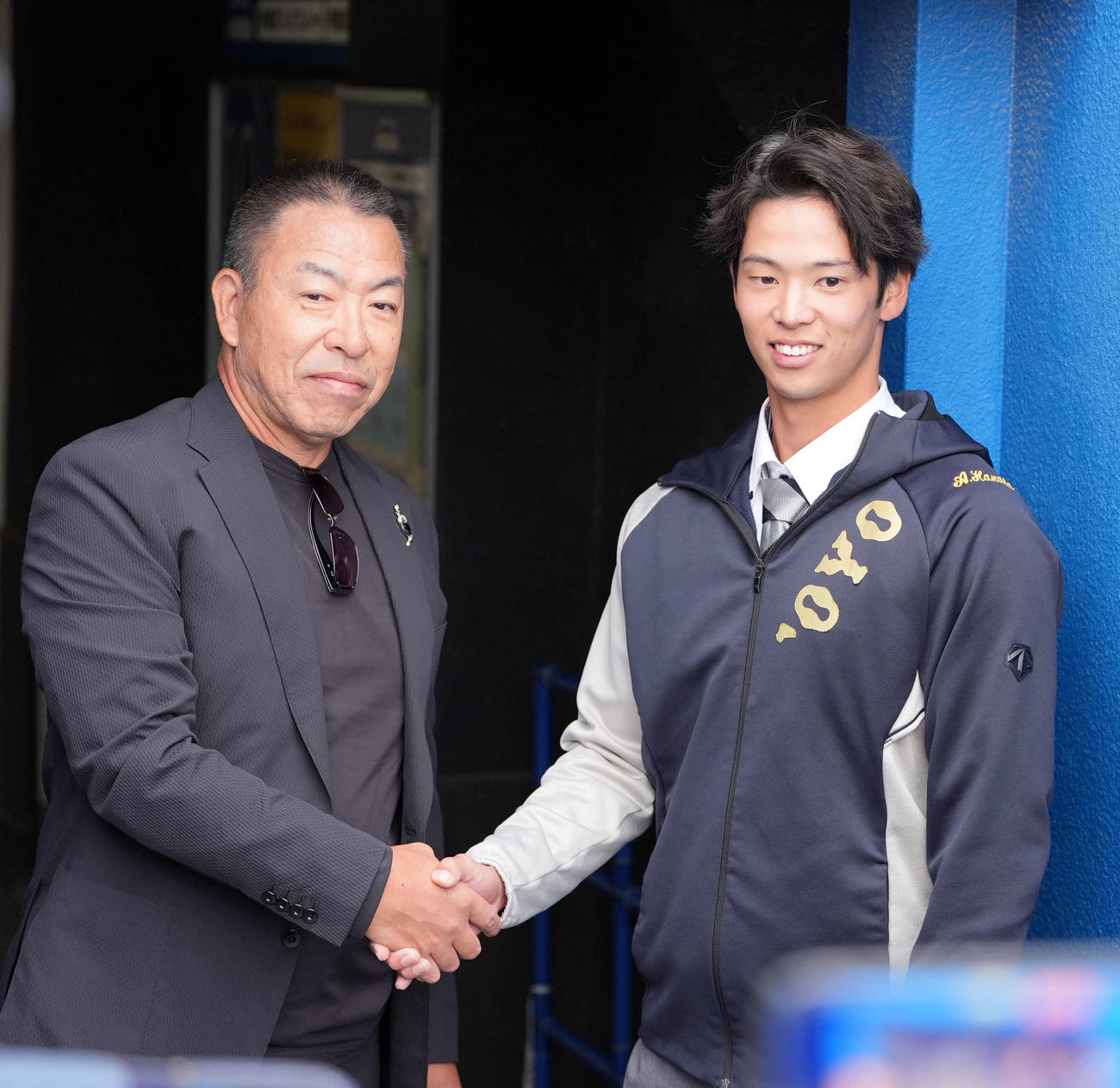 中大対東洋大の試合観戦に訪れる中日井上一樹監督（左）と握手する中日ドラフト6位の東洋大・花田（撮影・小島史椰）
