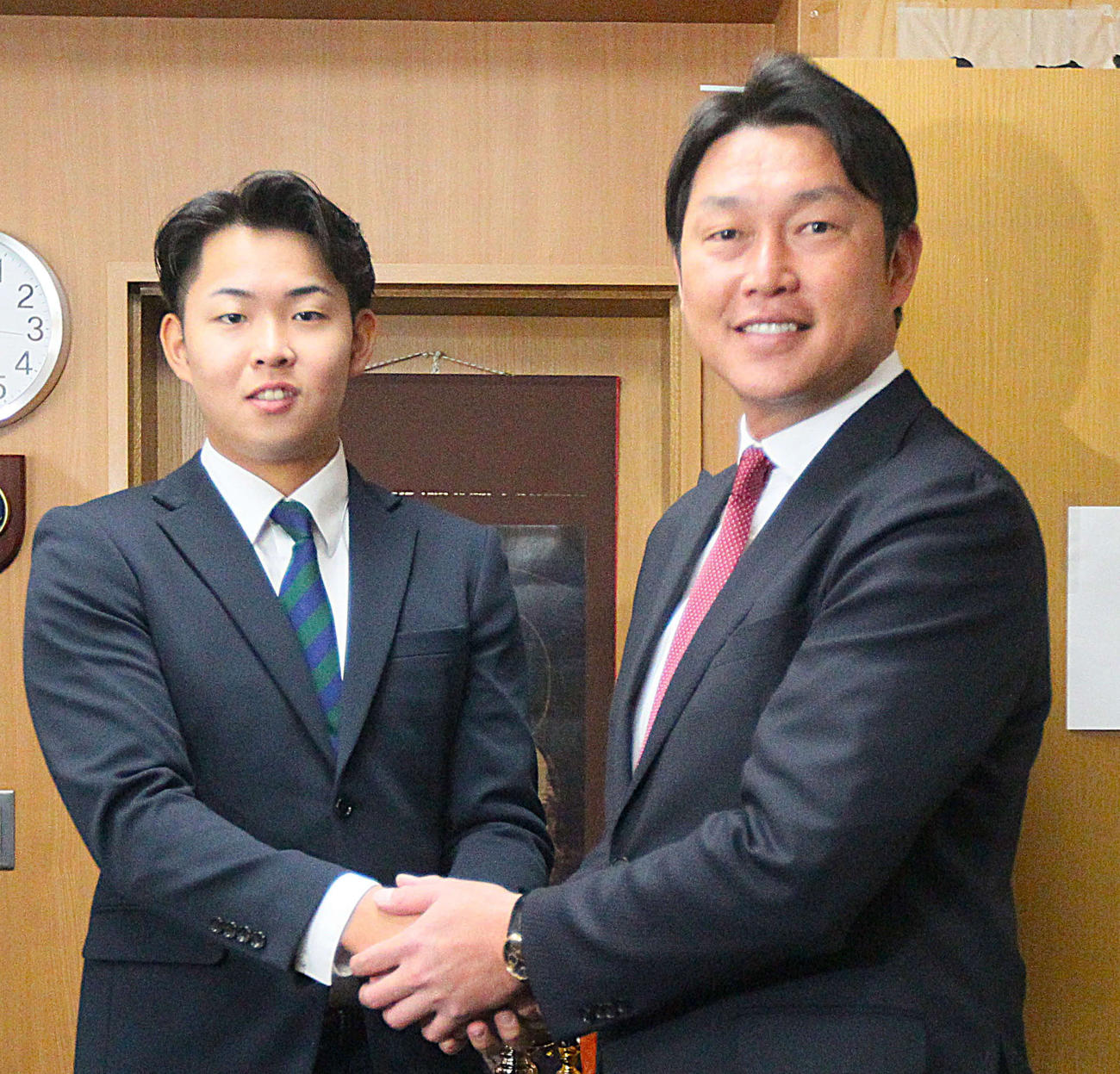 握手を交わす広島・新井監督（左）と仙台大・平川（撮影・高橋香奈）
