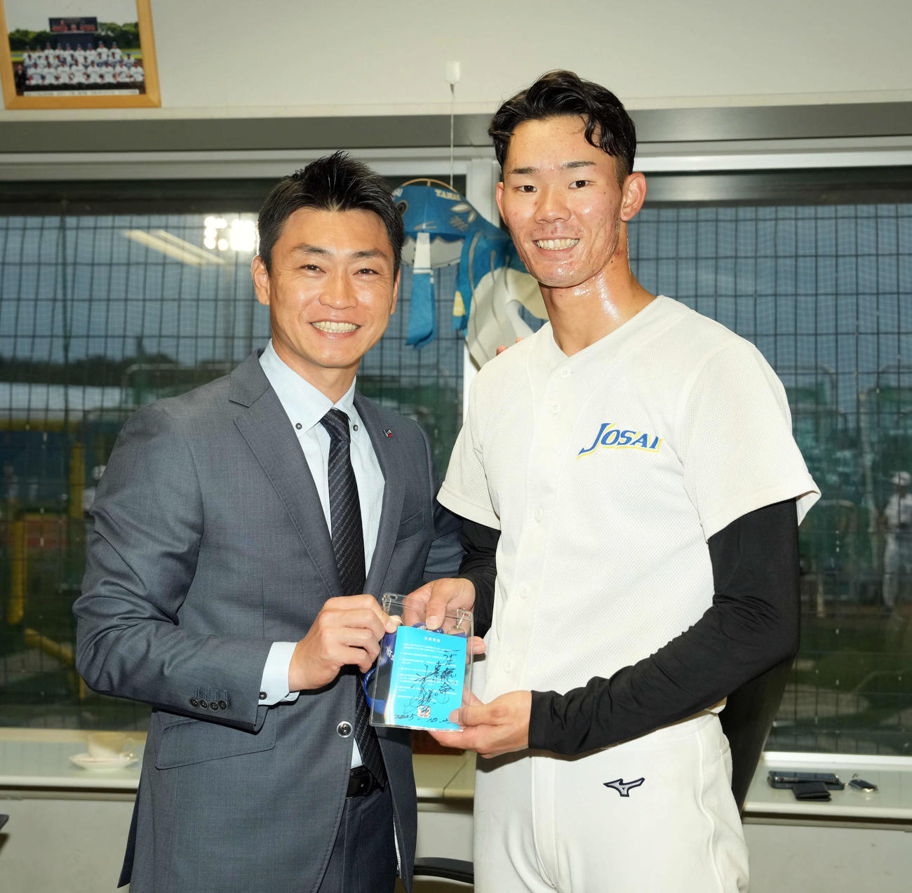 ヤクルト池山監督の直筆サインが入ったパスを青木GM特別補佐（左）から手渡される城西大・松川（撮影・たえ見朱実）