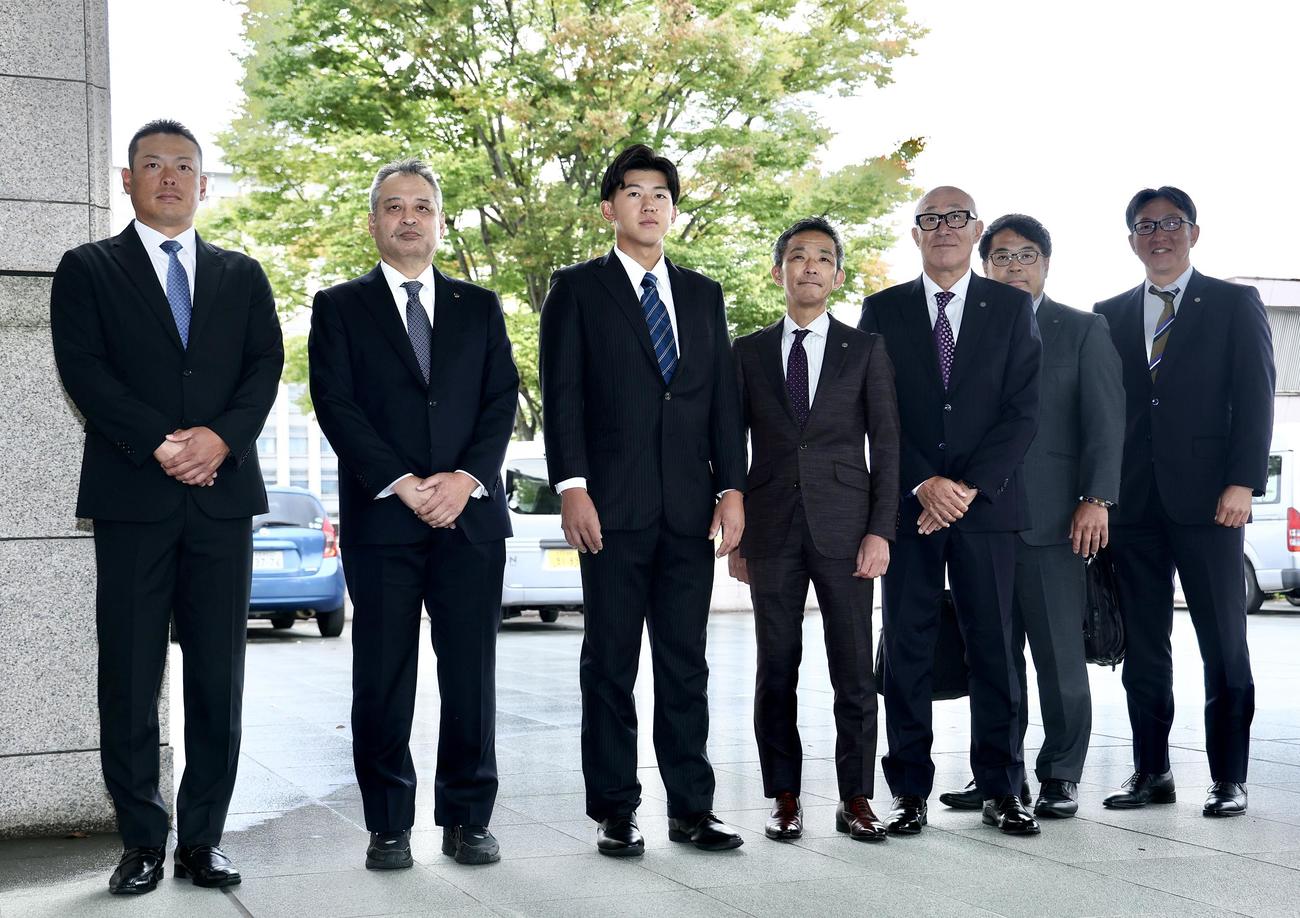 高口コーチ（左）、佐藤監督（左から2人目）と阪神球団職員を出迎える創価大・立石（中央）。右から阪神吉野スカウト、東編成ディレクター、畑山統括スカウト、竹内球団副本部長（撮影・河田真司）