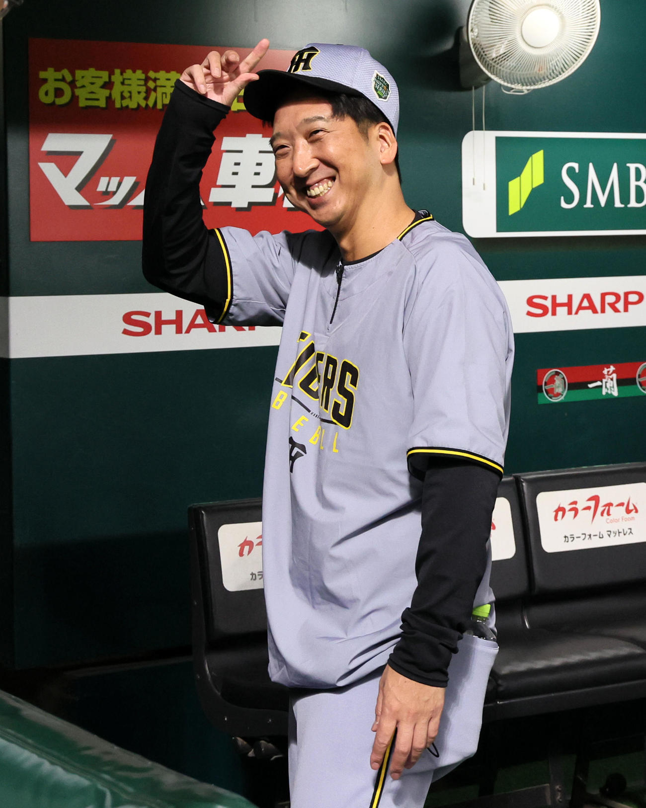 練習を終えベンチで関係者と笑顔であいさつする阪神藤川監督（撮影・加藤哉）