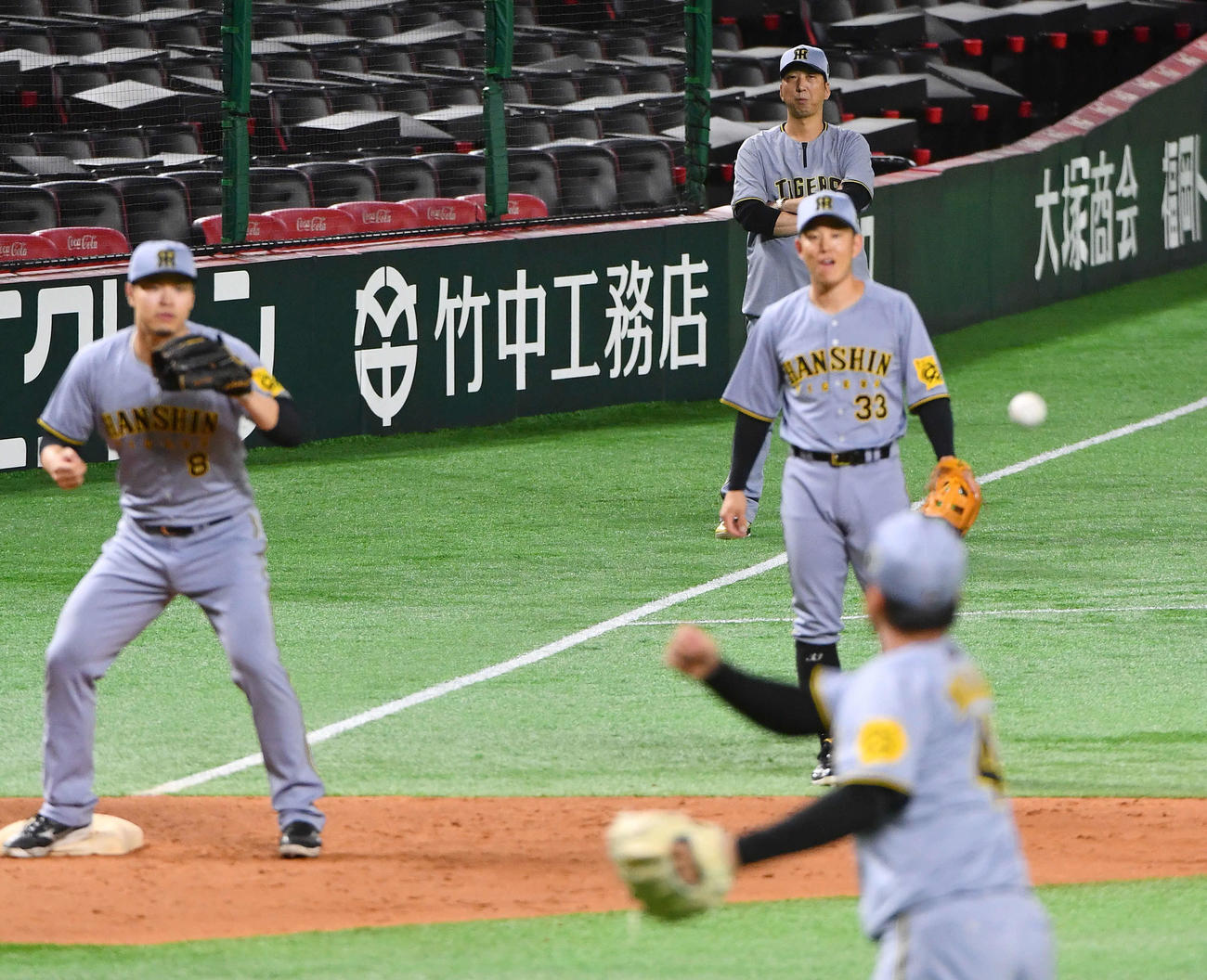 投内連係を行う村上（手前）を見守る阪神藤川監督（右奥）。中列左は佐藤輝、同右は糸原（撮影・岩下翔太）
