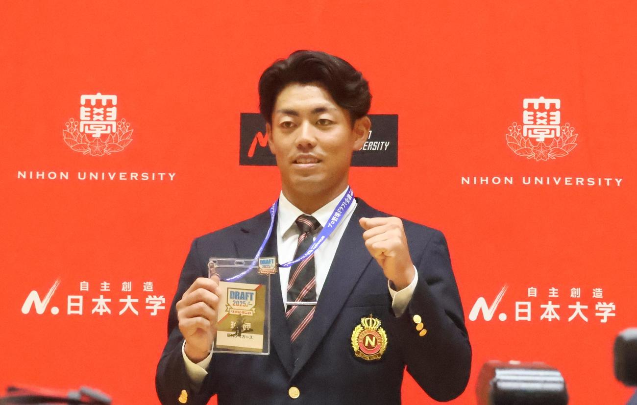 阪神藤川監督のサインが入ったドラフト会議2025のIDを持ちポーズを決めるドラフト2位の日大・谷端（撮影・塚本光）