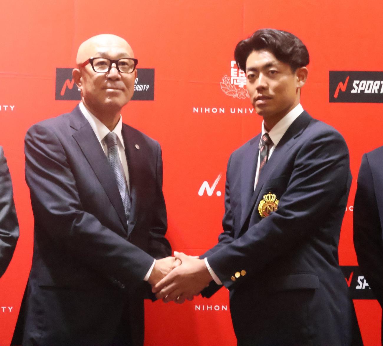 阪神畑山統括スカウト（左）と握手するドラフト2位の日大・谷端（撮影・塚本光）